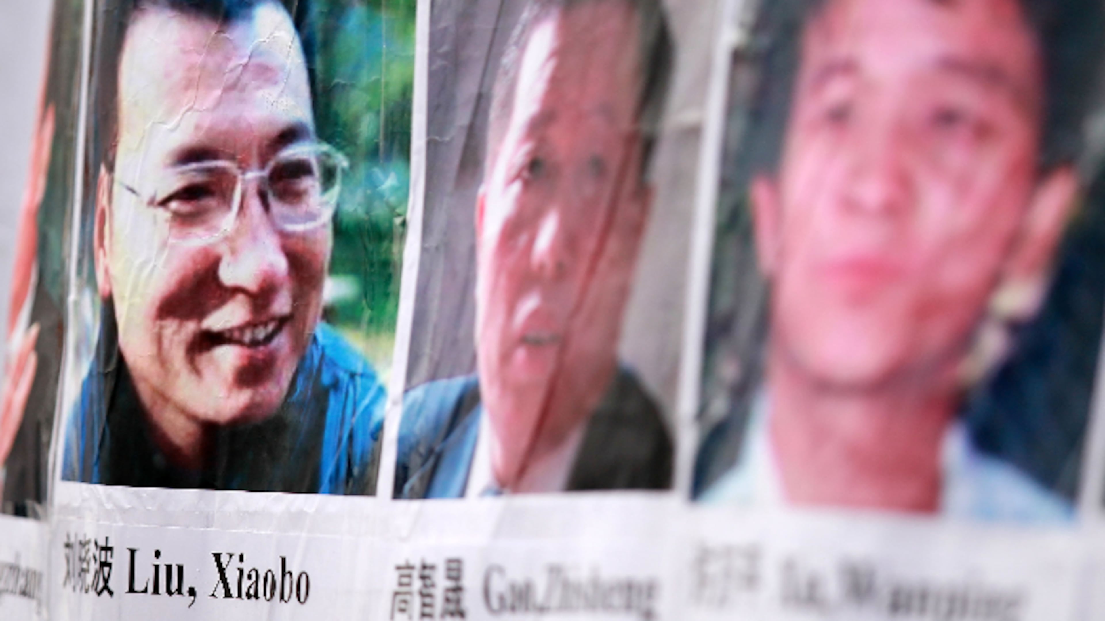 Pictures of Chinese dissidents, including Nobel Prize laureate Liu Xiaobo (L), are seen on a banner during a rally for Liu December 10, 2010 in Washington, DC.