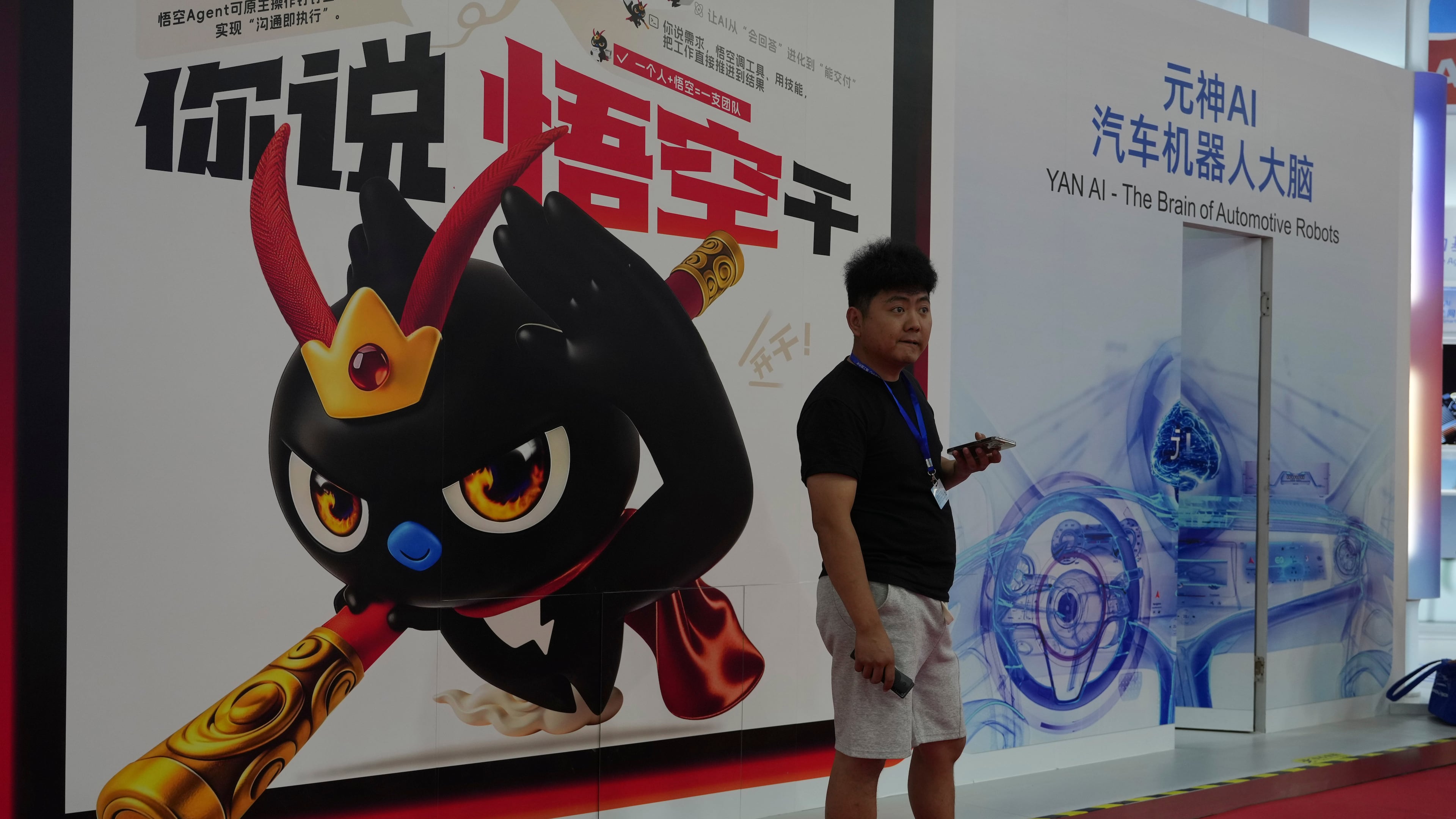 A man stands near a poster promoting the AI agent from Alibaba at the China International Supply Chain Expo in Beijing on Monday, June 22, 2026. (AP Photo/Ng Han Guan)