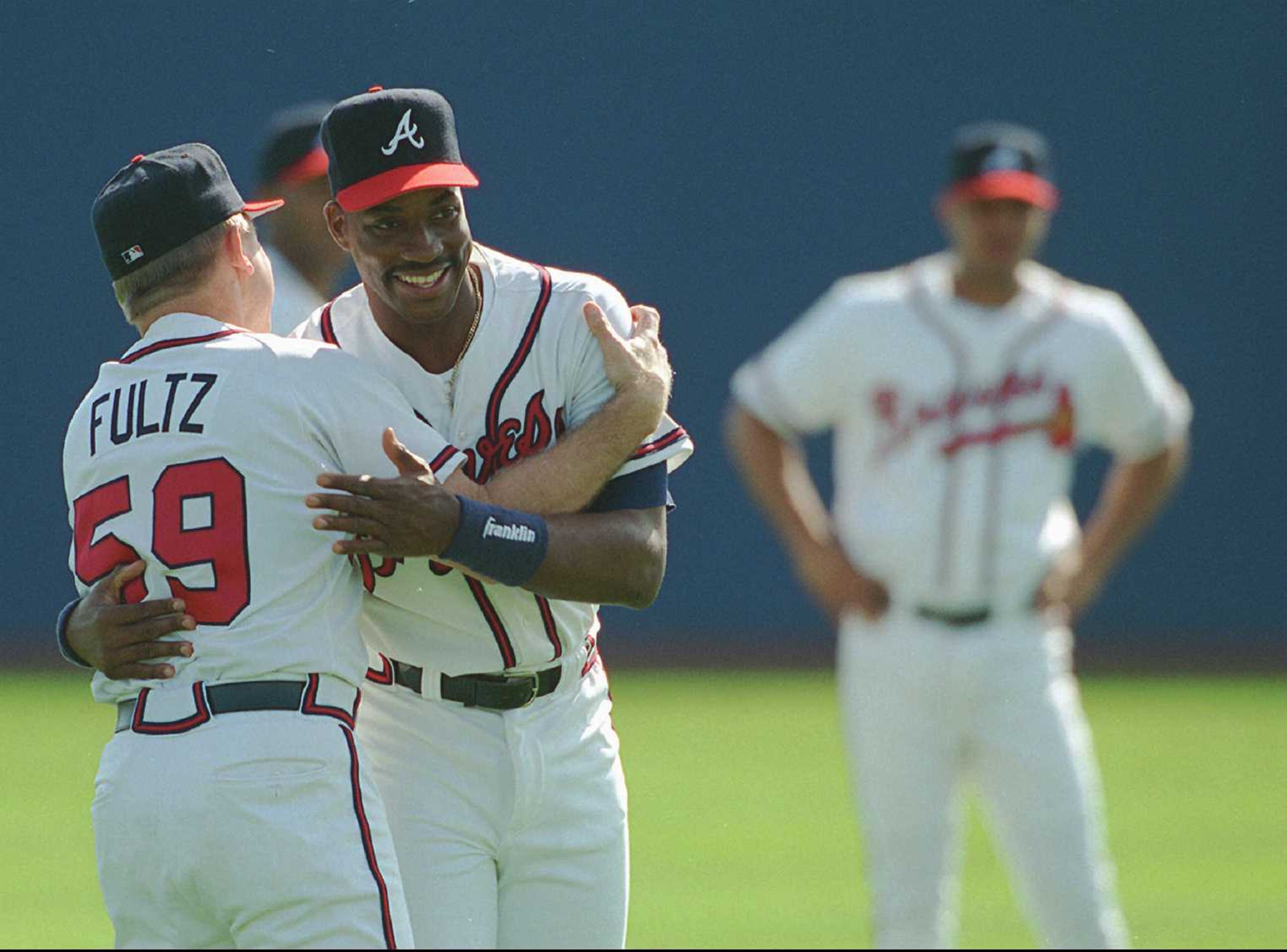 Coach Frank Fultz give Fred McGriff a welcome hug during the first full squad workout at spring training at the West Palm Beach Municipal Stadium in 1996.