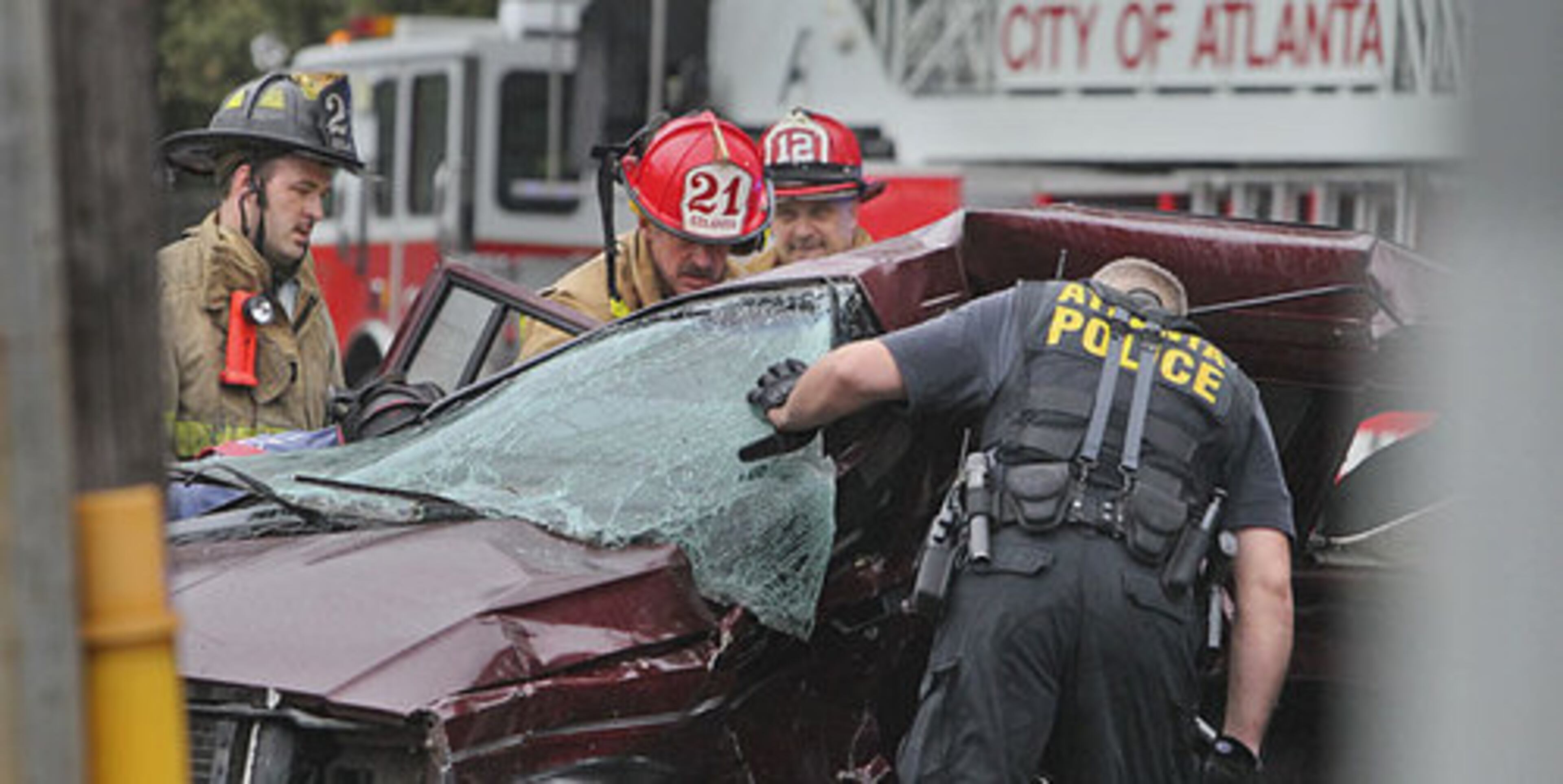 Police and firefighters examine one of the wrecked cars. A serious wreck during the Wednesday, Sept. 7, 2011 morning commute involved a motorist trapped inside an overturned vehicle on Peachtree Road at Peachtree Battle Avenue in Buckhead. That crash occurred at the end of a short police chase.