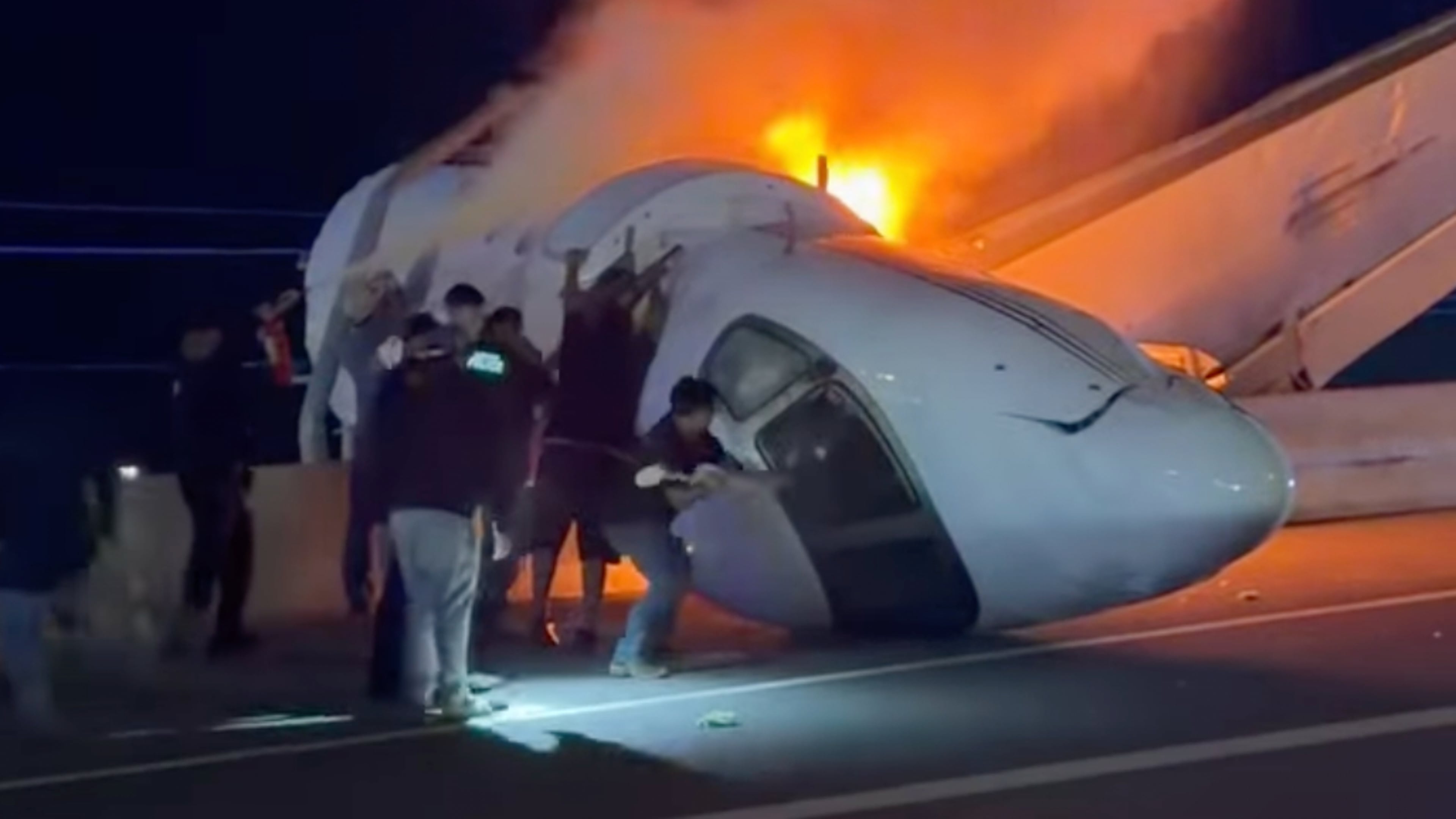 People attempt to pull passengers out of a plane after it crashed on a highway Tuesday, June 16, 2026, in Laredo, Texas. (Zayra Garza via AP)