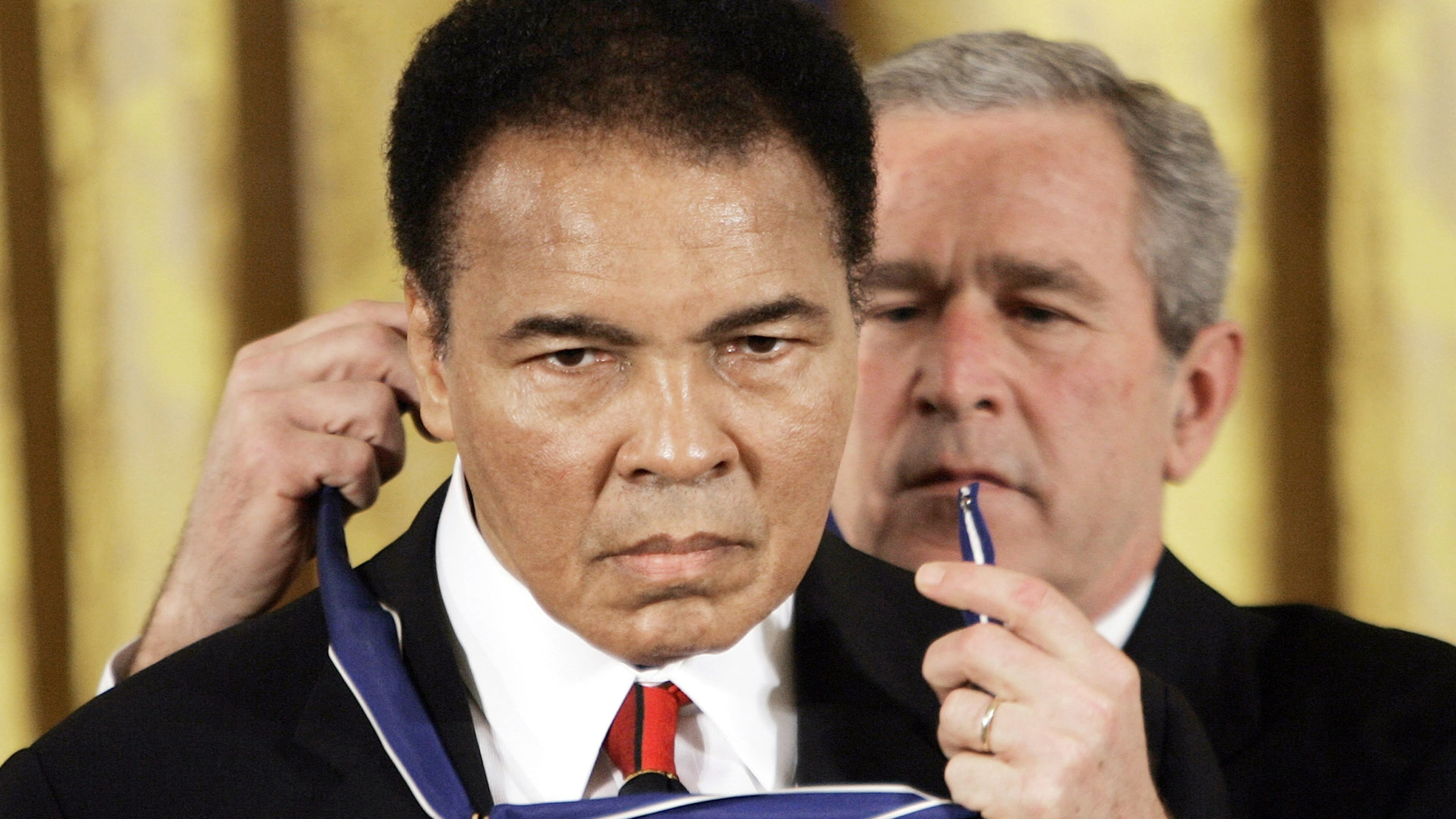 FILE - In this Nov. 9, 2005, file photo, President Bush presents the Presidential Medal of Freedom to boxer Muhammad Ali in the East Room of the White House. Ali, the magnificent heavyweight champion whose fast fists and irrepressible personality transcended sports and captivated the world, has died according to a statement released by his family Friday, June 3, 2016. He was 74. (AP Photo/Evan Vucci, File)