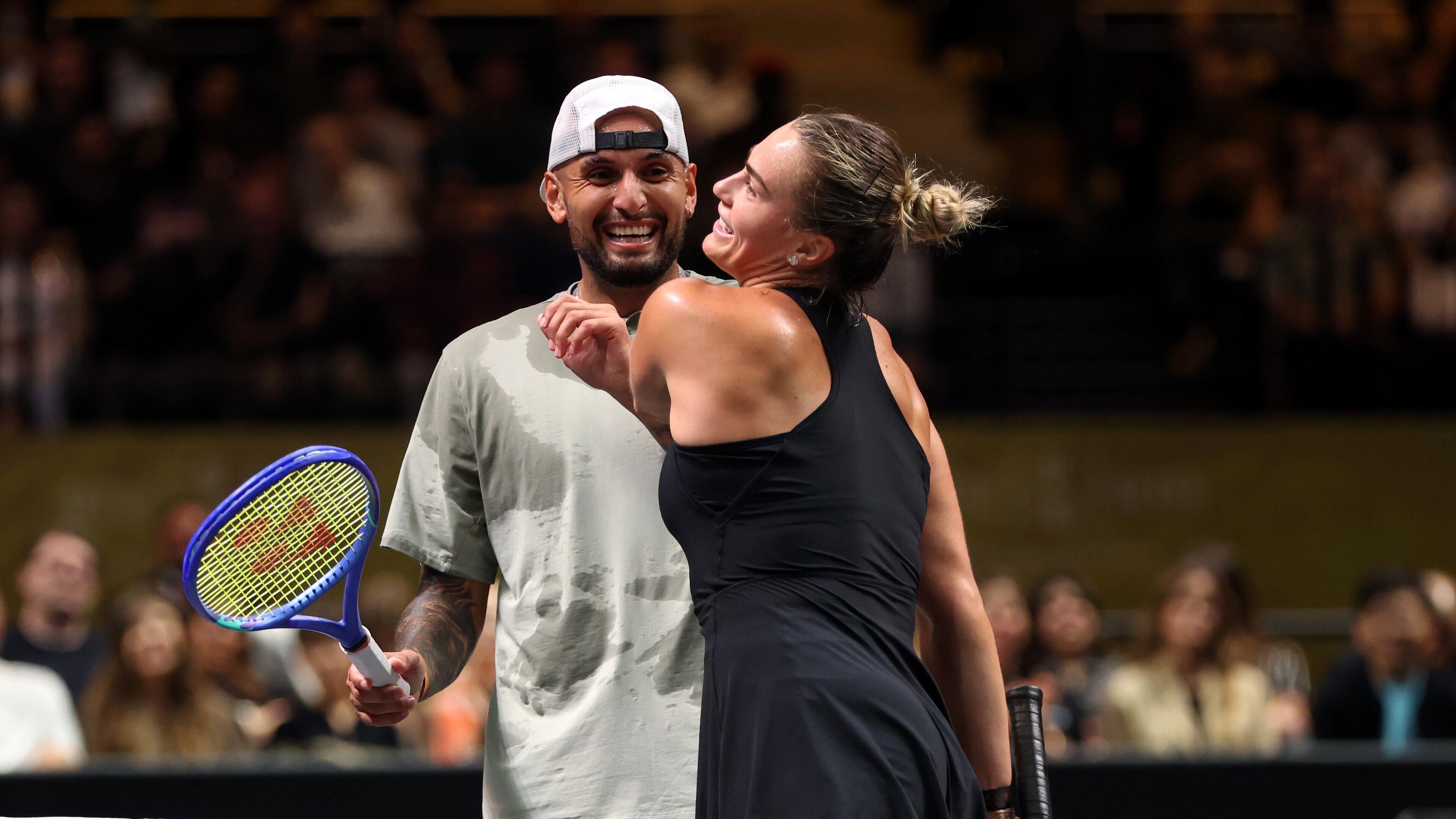 Nick Kyrgios, left, and Aryna Sabalenka interact at the net during their Battle of the Sexes match, in Dubai, United Arab Emirates, Sunday Dec. 28, 2025. (Christopher Pike/Pool Photo via AP)