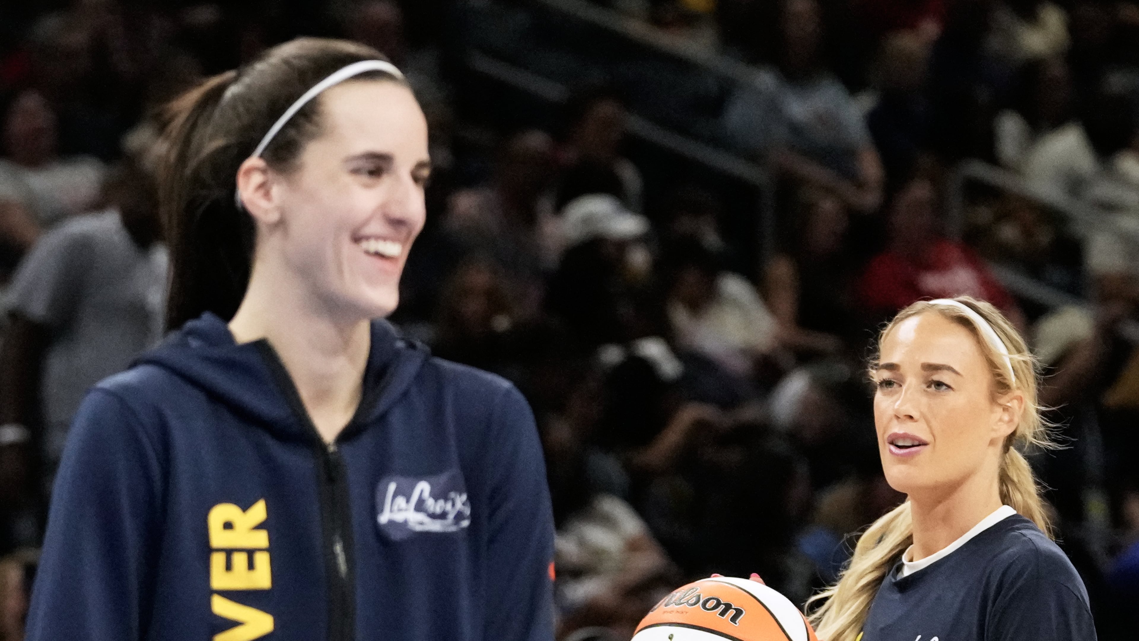 Indiana Fever guard Sophie Cunningham, right, warms up as guard Caitlin Clark, left, talks with teammates before a WNBA basketball game against the Chicago Sky, Sunday, Aug. 23, 2026, in Chicago. (AP Photo/Nam Y. Huh)