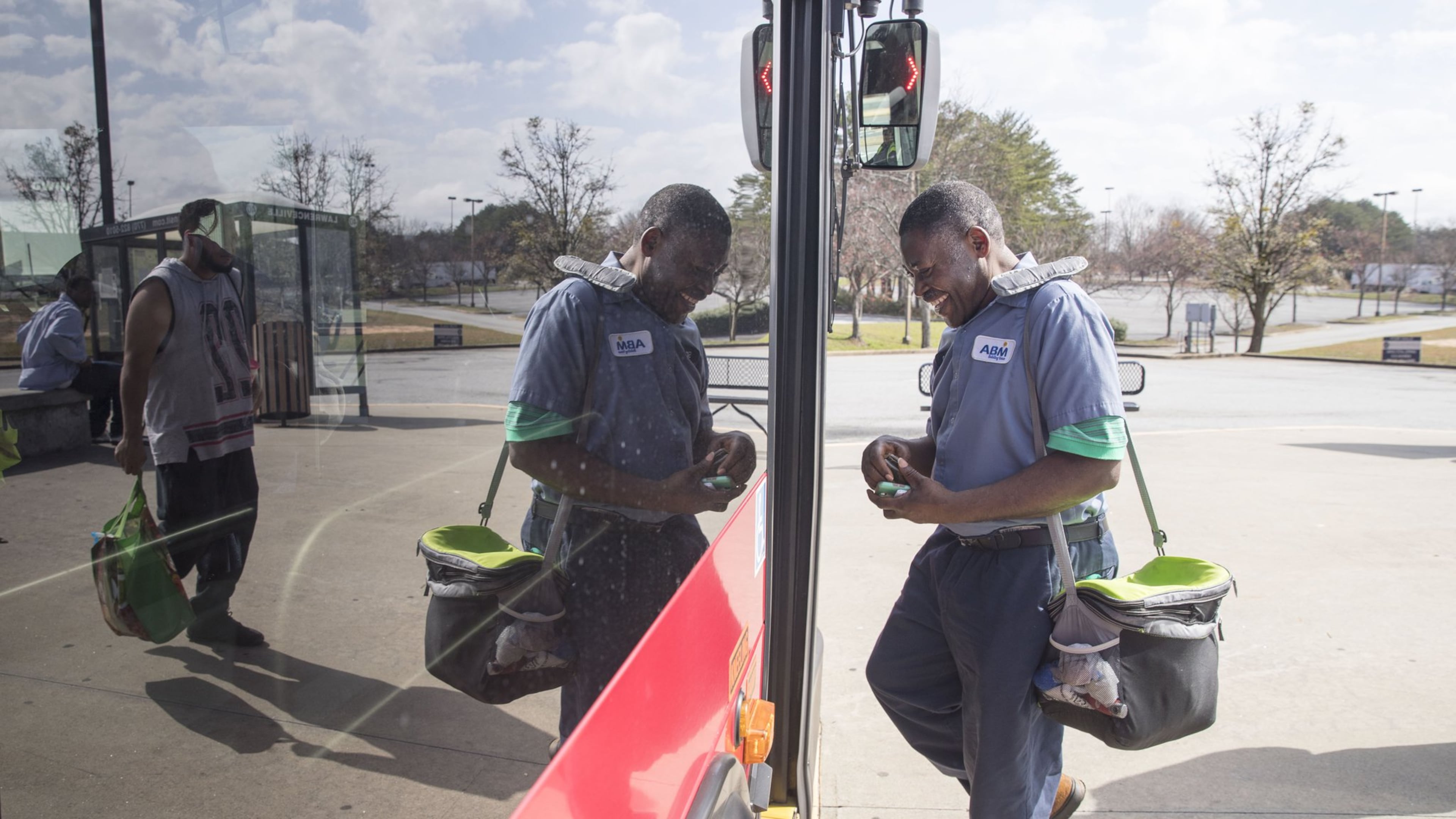 Simon Tshimanga of Duluth jokes with a Gwinnett County transit bus driver while boarding a bus at the Gwinnett Transit Center in Duluth, Friday, February 23, 2018. Simon, a second shift custodian with ABM, uses the transit system to get to work. ALYSSA POINTER/ALYSSA.POINTER@AJC.COM