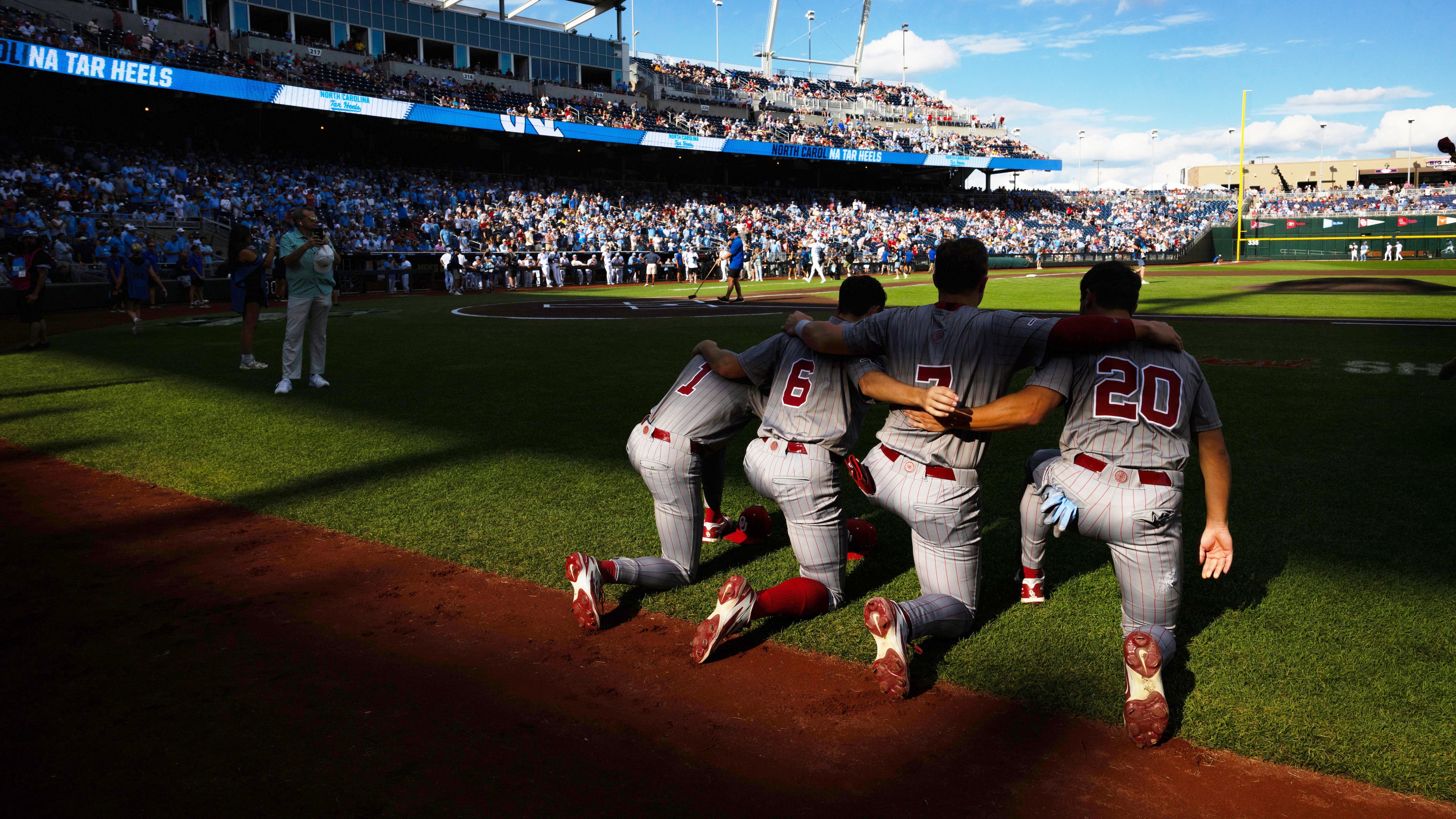 Oklahoma's Jason Walk (1), Kyle Branch (6), Jaxon Willits (7) and Trey Gambill (20) kneel together before playing against North Carolina in Game 3 of the NCAA College World Series baseball finals in Omaha, Neb., Monday, June 22, 2026. (AP Photo/Rebecca S. Gratz)