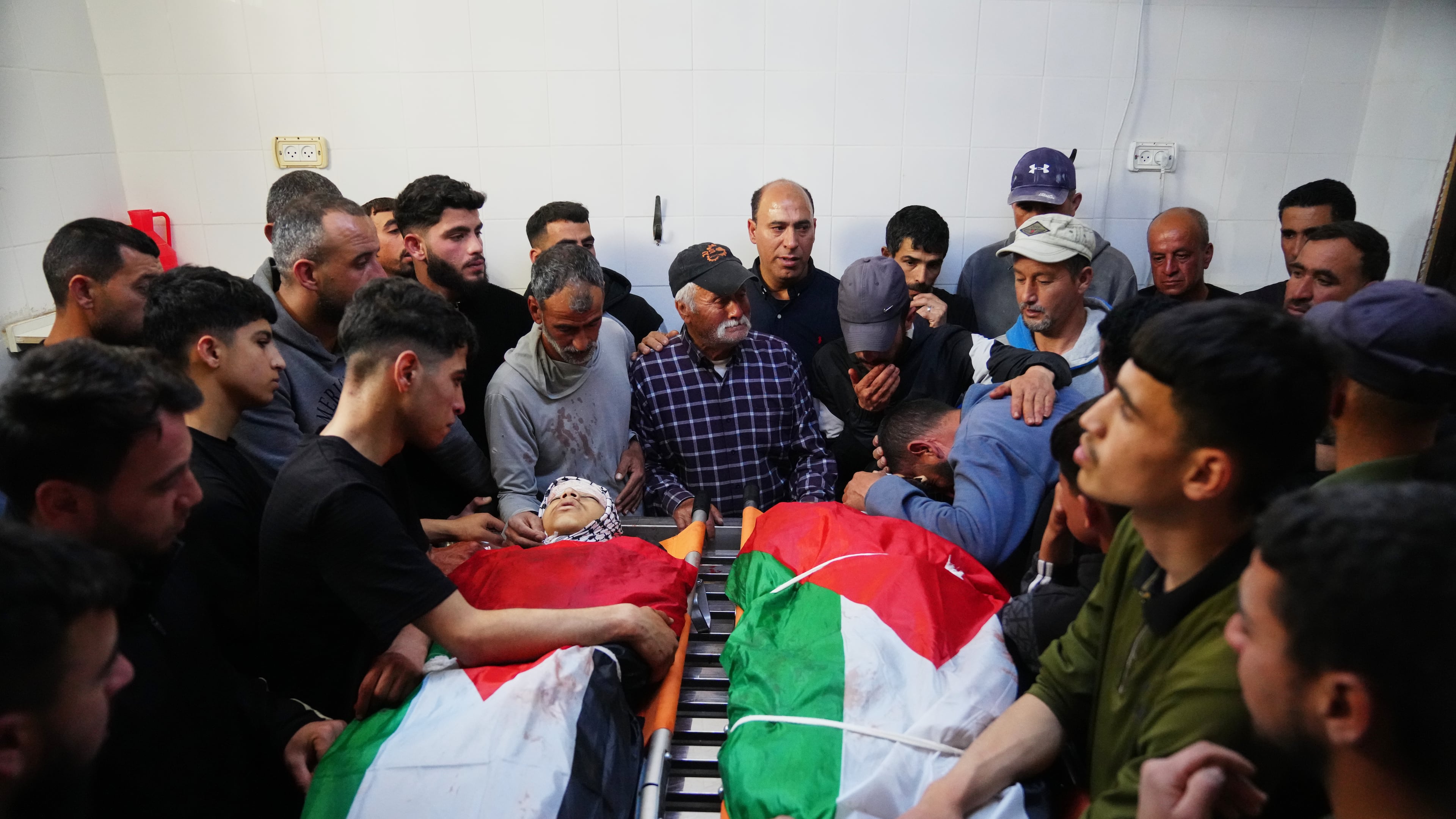 Mourners gather around the bodies of Aws al-Na'san and Jihad Abu Naim, residents of the West Bank village of al-Mughayyir, at the hospital's morgue in the West Bank city of Ramallah, Tuesday, April 21, 2026. (AP Photo/Mahmoud Illean)