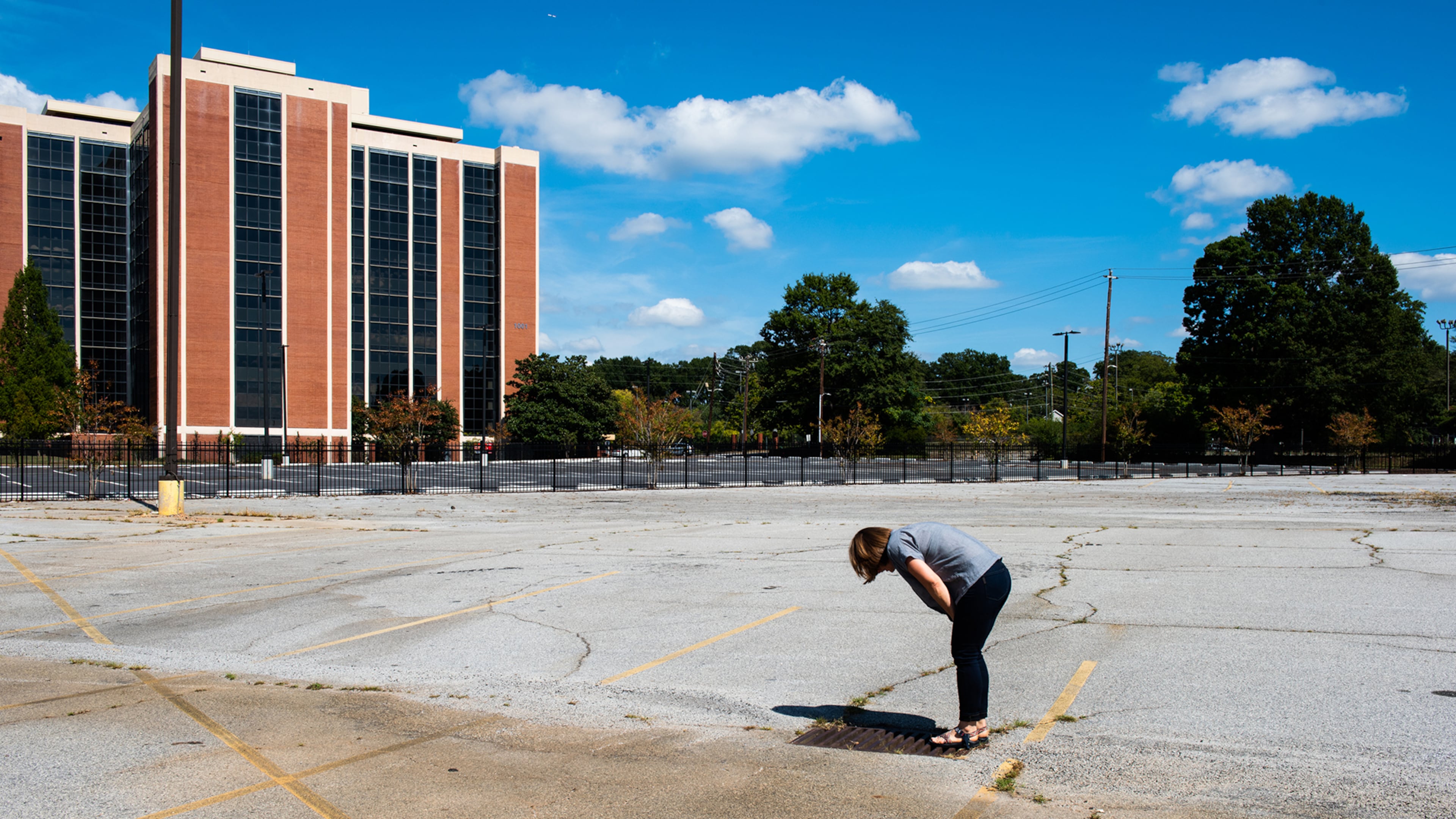 Atlanta artist and writer Virginie Kippelen's environmental documentary photo project "Lost in Sight" documents the hidden origins of the Flint River's headwaters just north of Hartsfield-Jackson Atlanta International airport and largely hidden from public view. Here, Hannah Palmer, coordinator of Finding the Flint, looks down the storm drain in downtown East Point.
Courtesy of Virginie Kippelen