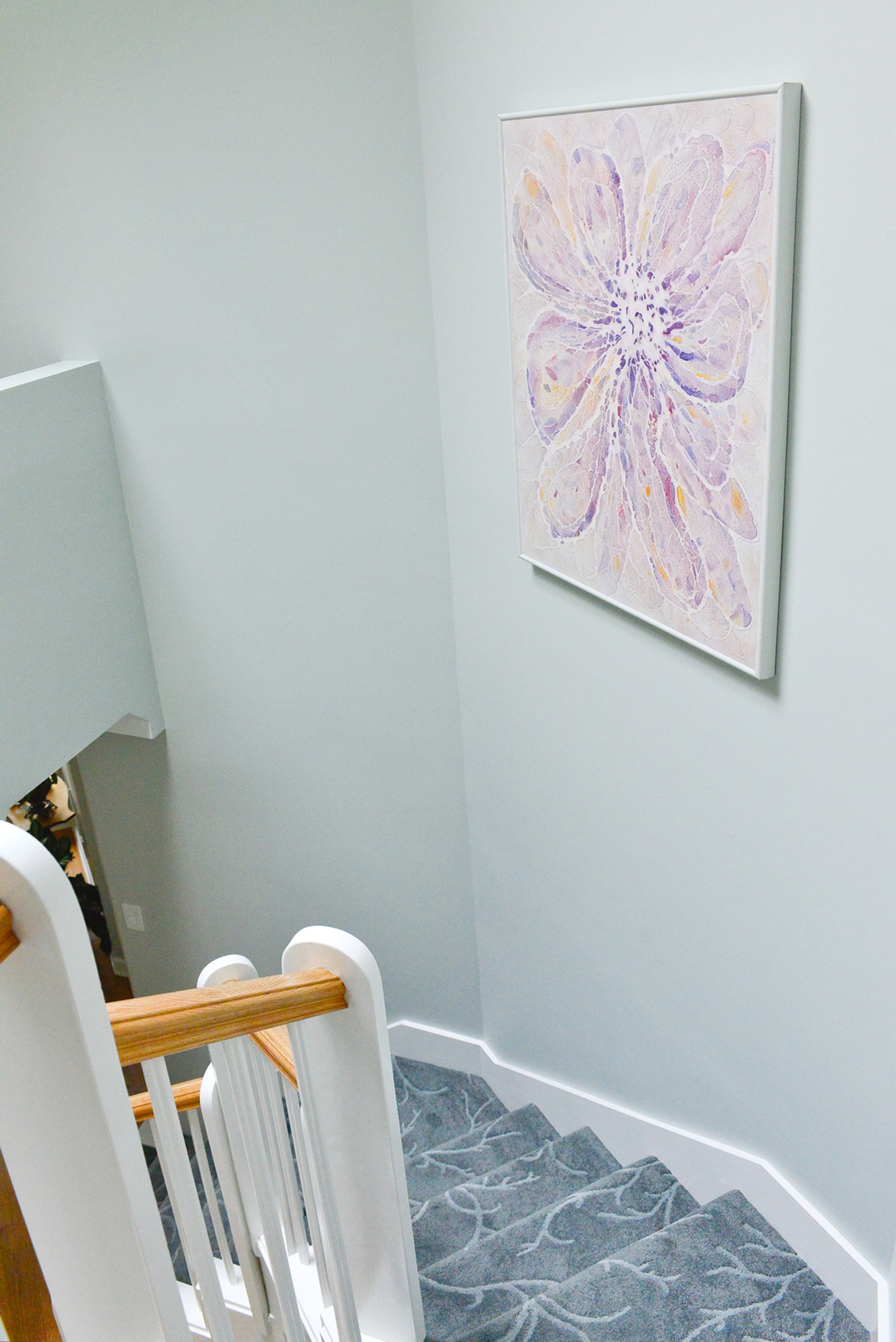 The unique octagonal stairwell in this Roswell home is carpeted in the Branching Out design in a Wedgewood color, from Moda Floors and Interiors. The vines in the gray carpet appear to stretch all the way down the stairs. The walls are painted in satin Sherwin-Williams Pearl Gray.
