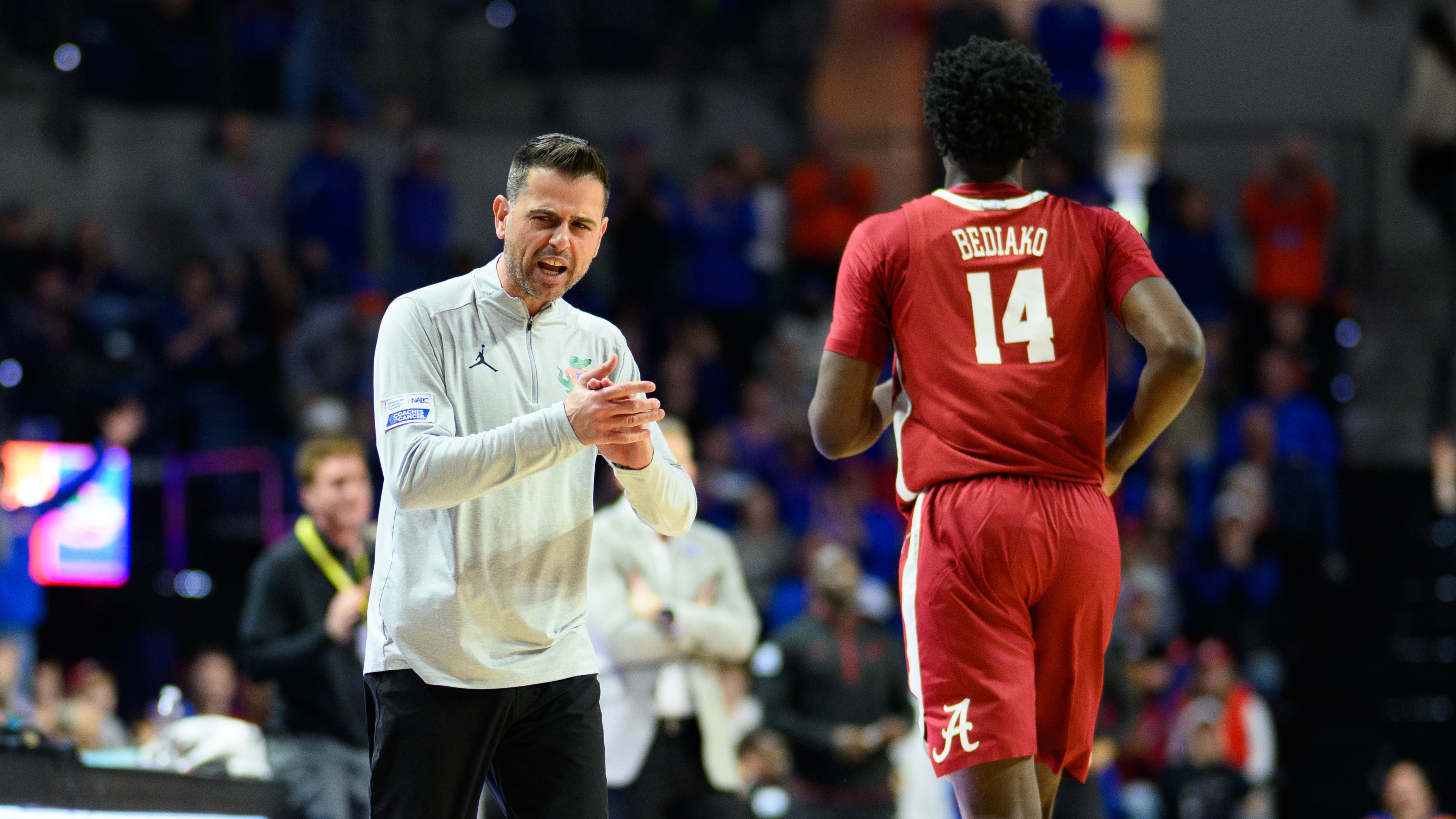 Florida head coach Todd Golden, left, claps and talks to Alabama center Charles Bediako (14) who walks off the court after fouling out during the second half of an NCAA college basketball game, Sunday, Feb. 1, 2026, in Gainesville, Fla. (AP Photo/Noah Lantor)