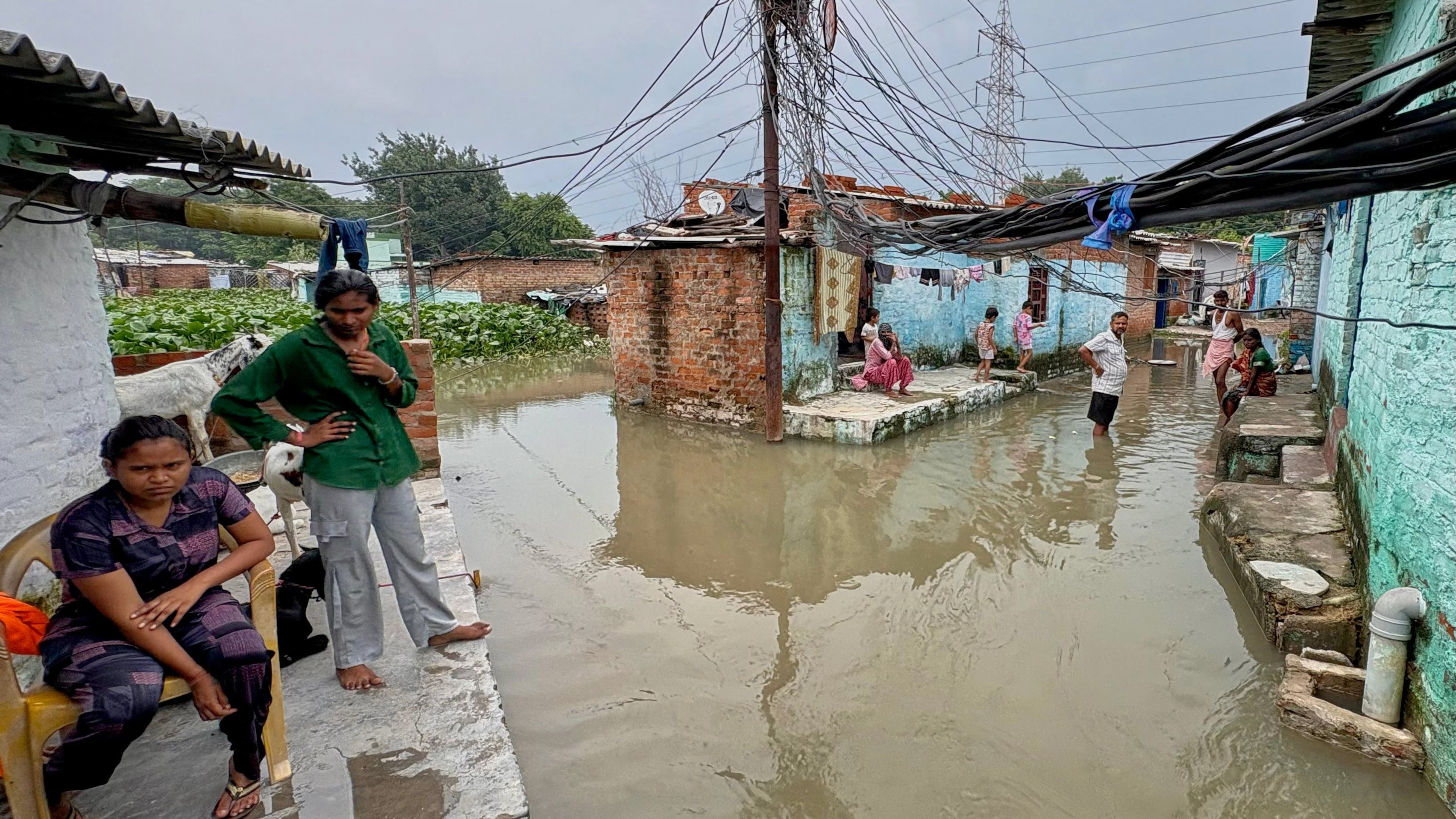 Residents of a low-lying neighborhood watch as floodwaters submerge their area following heavy rains in Kanpur, India, on Sept. 22, 2026. (AP Photo)