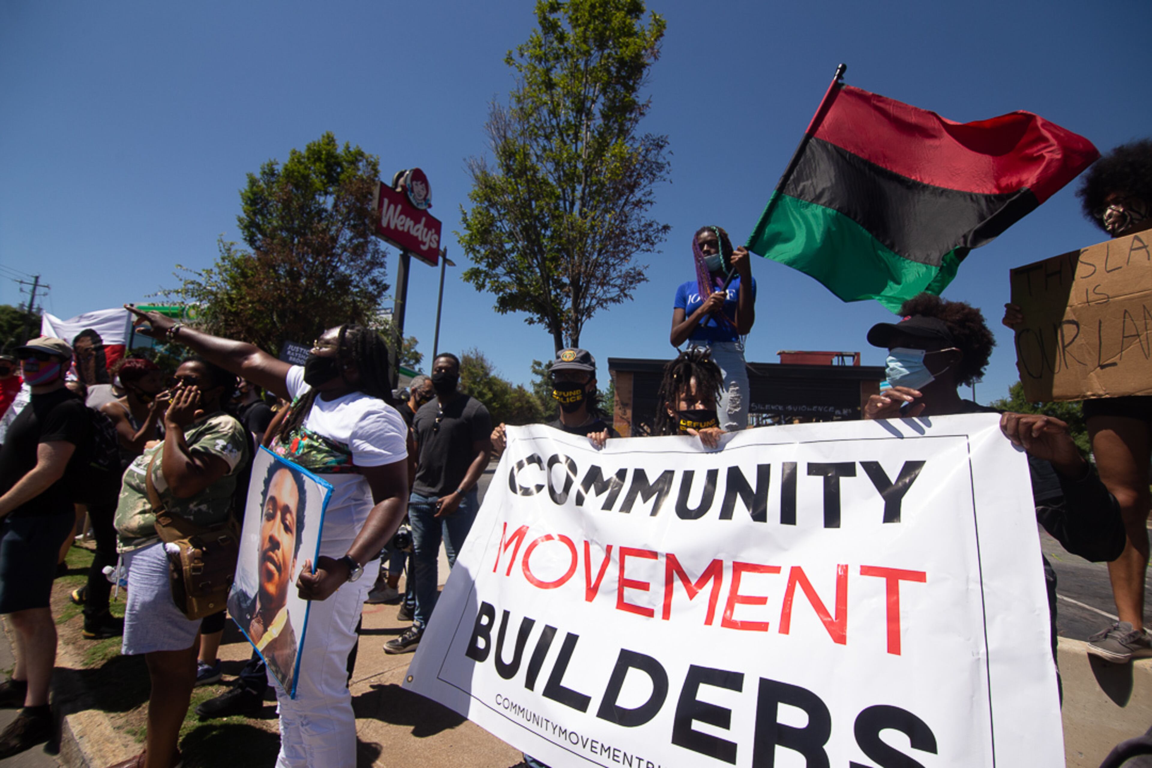 Yvette Dixon waves her flag during a rally at the Wendy's on University Avenue in Atlanta on Saturday, July 11, 2020. (Photo: Steve Schaefer for The Atlanta Journal-Constitution)