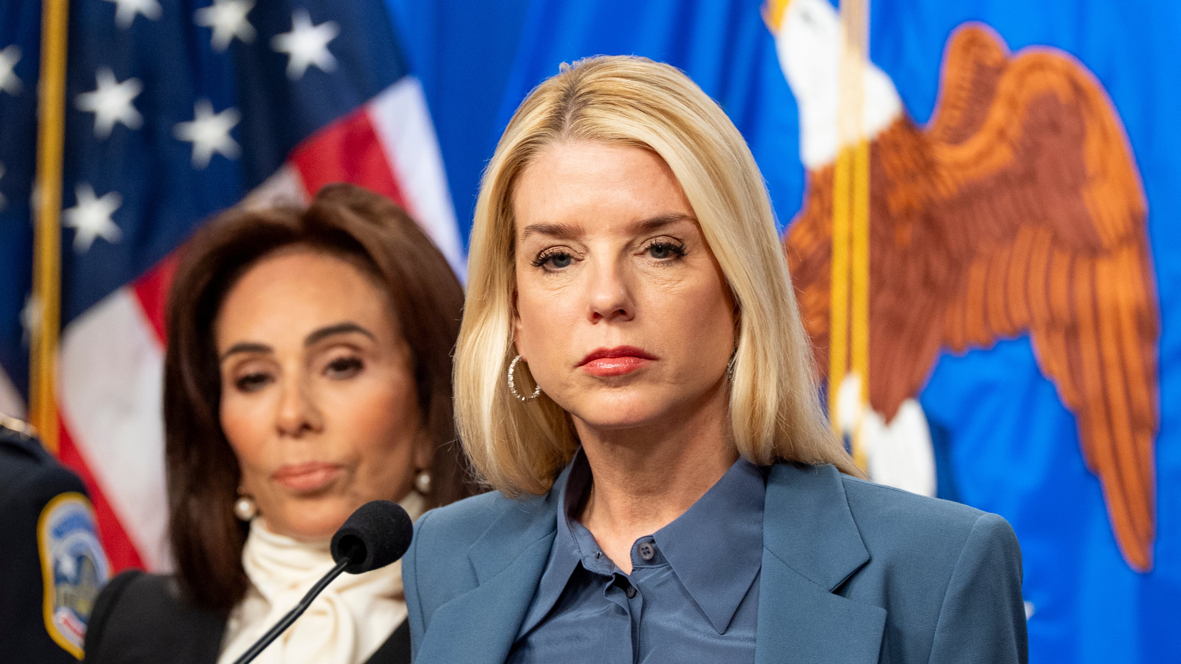 Attorney General Pam Bondi, with U.S. Attorney Jeanine Pirro behind, pauses while speaking during a news conference at the Department of Justice, Thursday, Dec. 4, 2025, in Washington. (AP Photo/Alex Brandon)