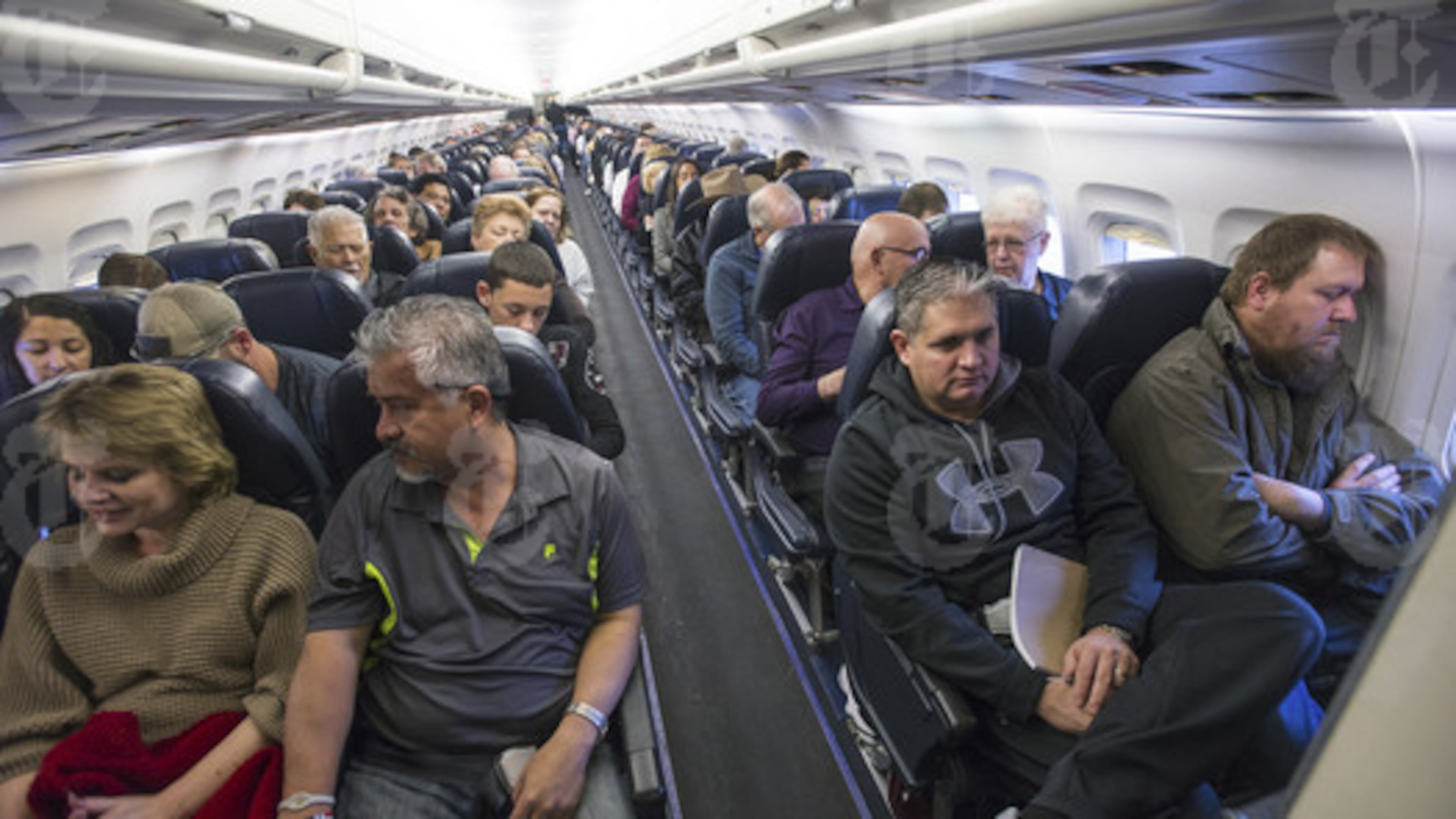 Passengers on a flight in Las Vegas, April 18, 2016. As planes fly at record capacity and new cabin configurations squeeze in ever more passengers, airlines are, intentionally or not, nudging fliers into paying extra to avoid drawing the proverbial short straw of the middle seat. (Joe Giron/The New York Times)