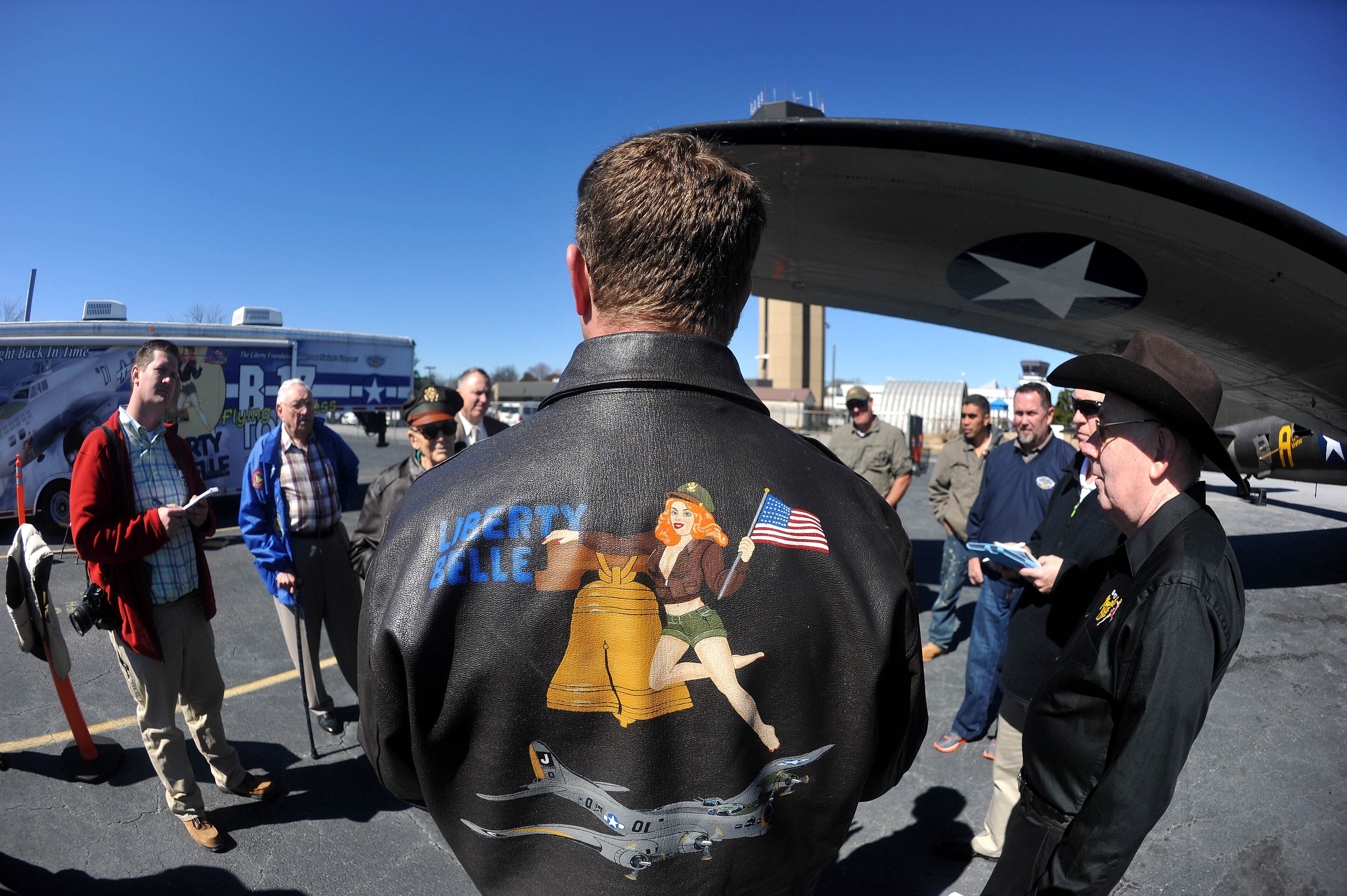 In this photo made with a fisheye lens, pilot Ray Fowler holds a preflight briefing under the wing of the "Movie Memphis Belle" bomber before aviation buffs and WWII veterans fly in a restored B-17 Flying Fortress at DeKalb-Peachtree Airport on Monday, Feb. 24, 2014. (AP Photo/David Tulis)