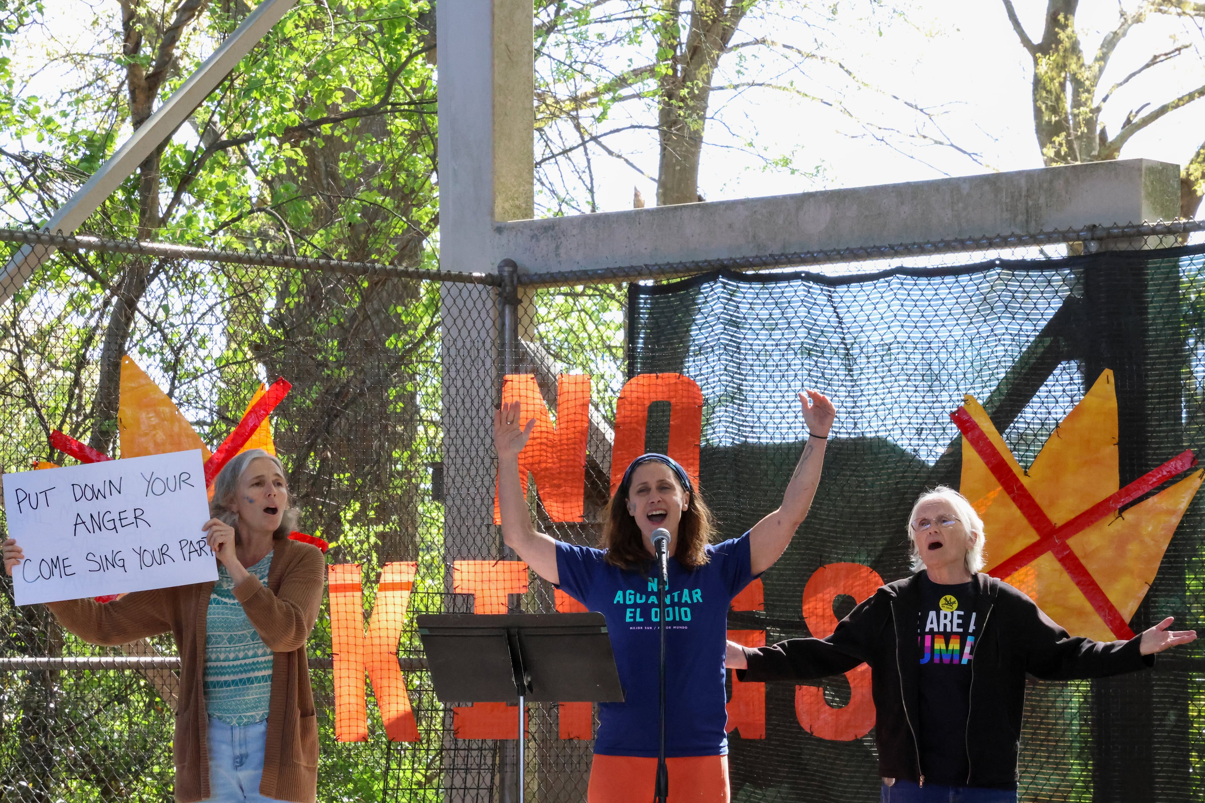 The Resistance Singers lead the crowd in song during a rally at Bishop Park in Athens on Saturday, March 28, 2026. Protesters gathered in 10 different locations around Georgia’s Congressional District 10, leading up to a “Democracy Fair” at Bishop Park as part of a nationwide day of “No Kings” demonstrations. Organizers estimate that a few thousand people participated, many of them first-time protesters. (C.J. Bartunek for the AJC)