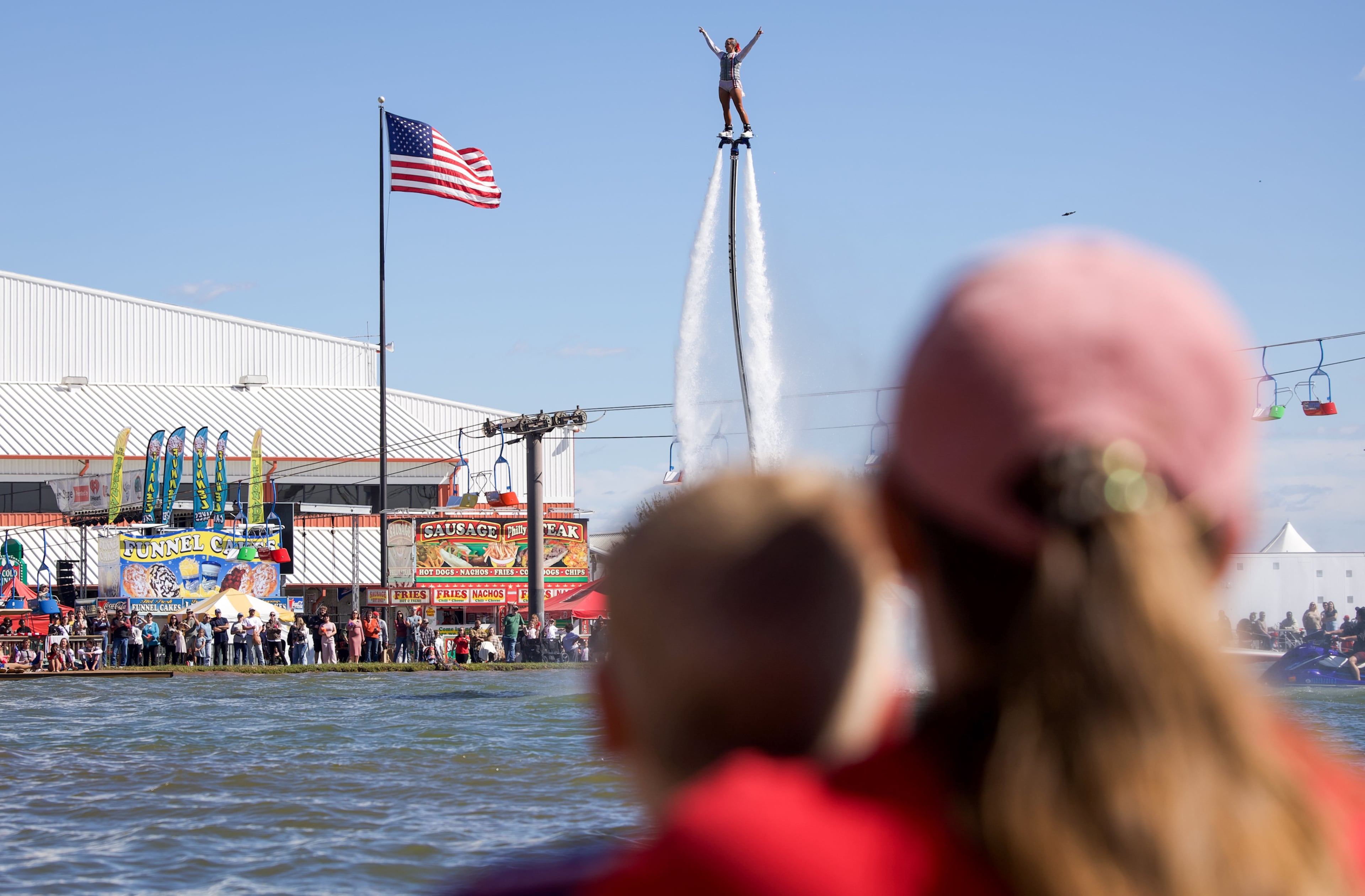 Fairgoers watch the Nerveless Nocks Extreme Water Ski and Stunt Show Spectacular at the Georgia National Fair in Perry, Georgia, on Oct. 17, 2026. The show features events such as a jetpack flying water circus and a water ski show. (Emily Laycock/UGA Photojournalism Workshop)