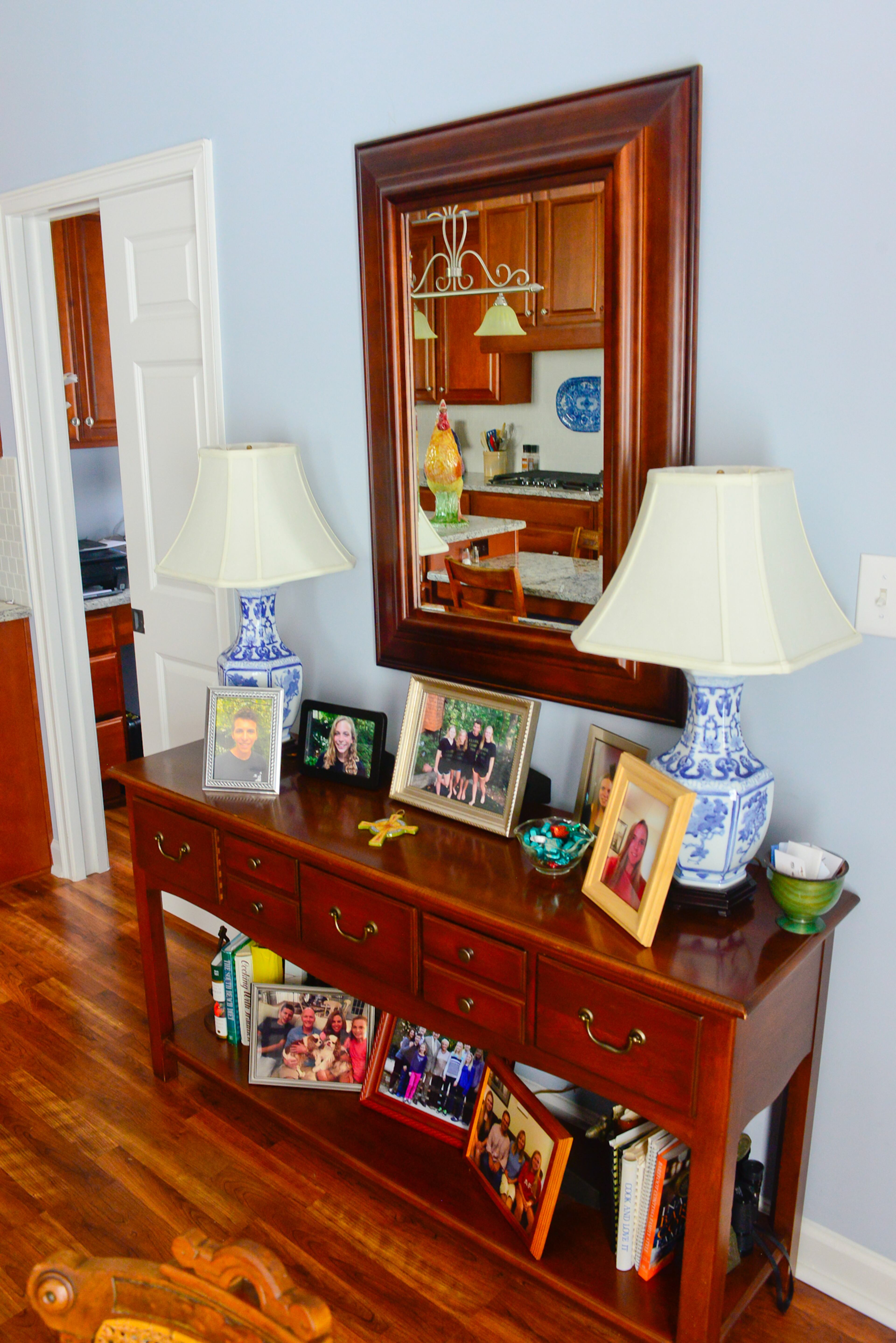 Blue-and-white pottery lamps bookend the sideboard. Set against the backdrop of a pale blue wall, the lamps tie the space together and echo similar Asian-inspired pottery pieces on the kitchen counter, in the living spaces and in the master bedroom.