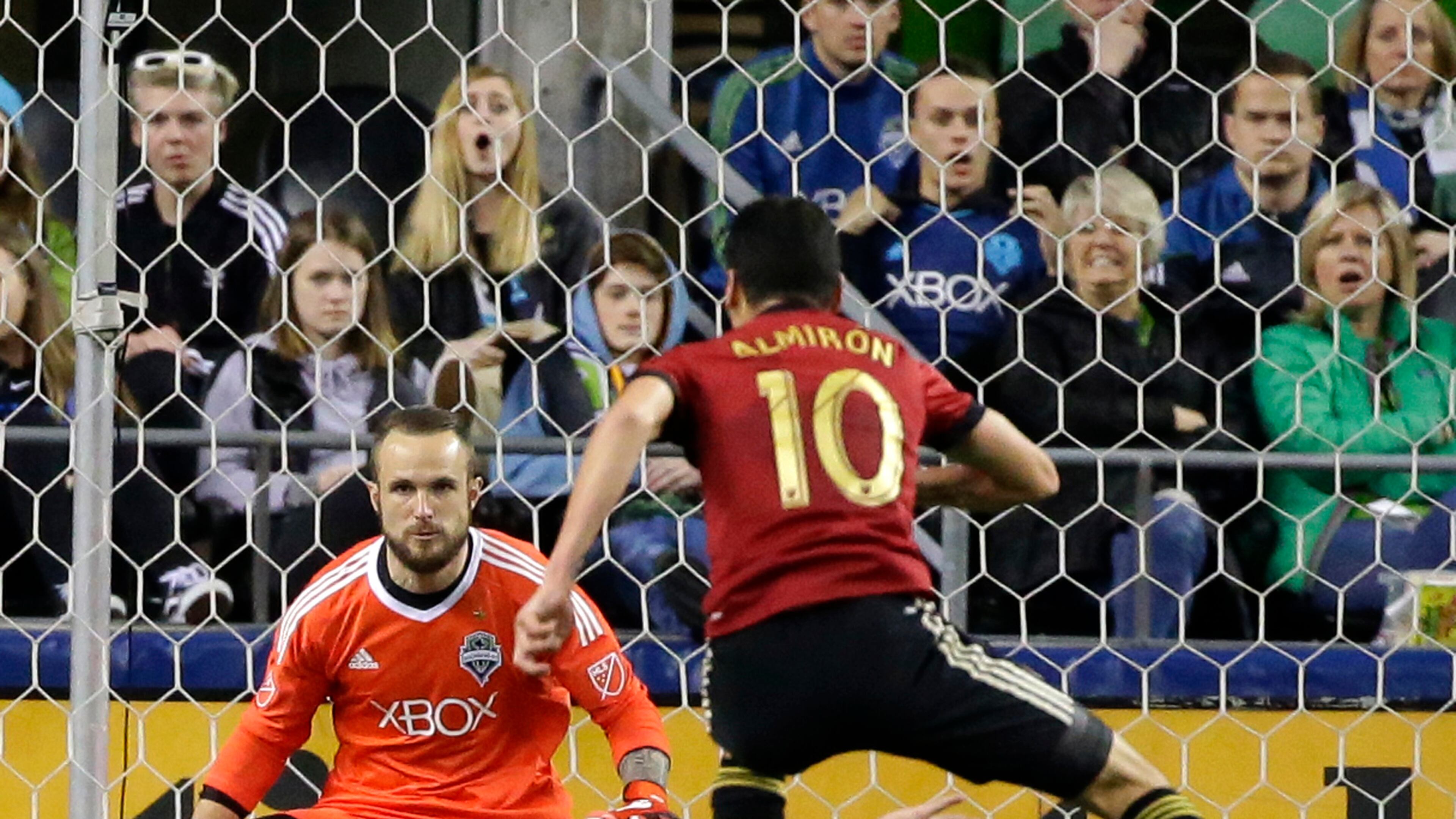 Seattle Sounders goalkeeper Stefan Frei, upper left, position to stop a shot by Atlanta United midfielder Miguel Almiron (10) as Almiron leaps over Sounders’ Osvaldo Alonso in the second half of an MLS soccer match, Friday, March 31, 2017, in Seattle. The match ended in a 0-0 tie. (AP Photo/Ted S. Warren)