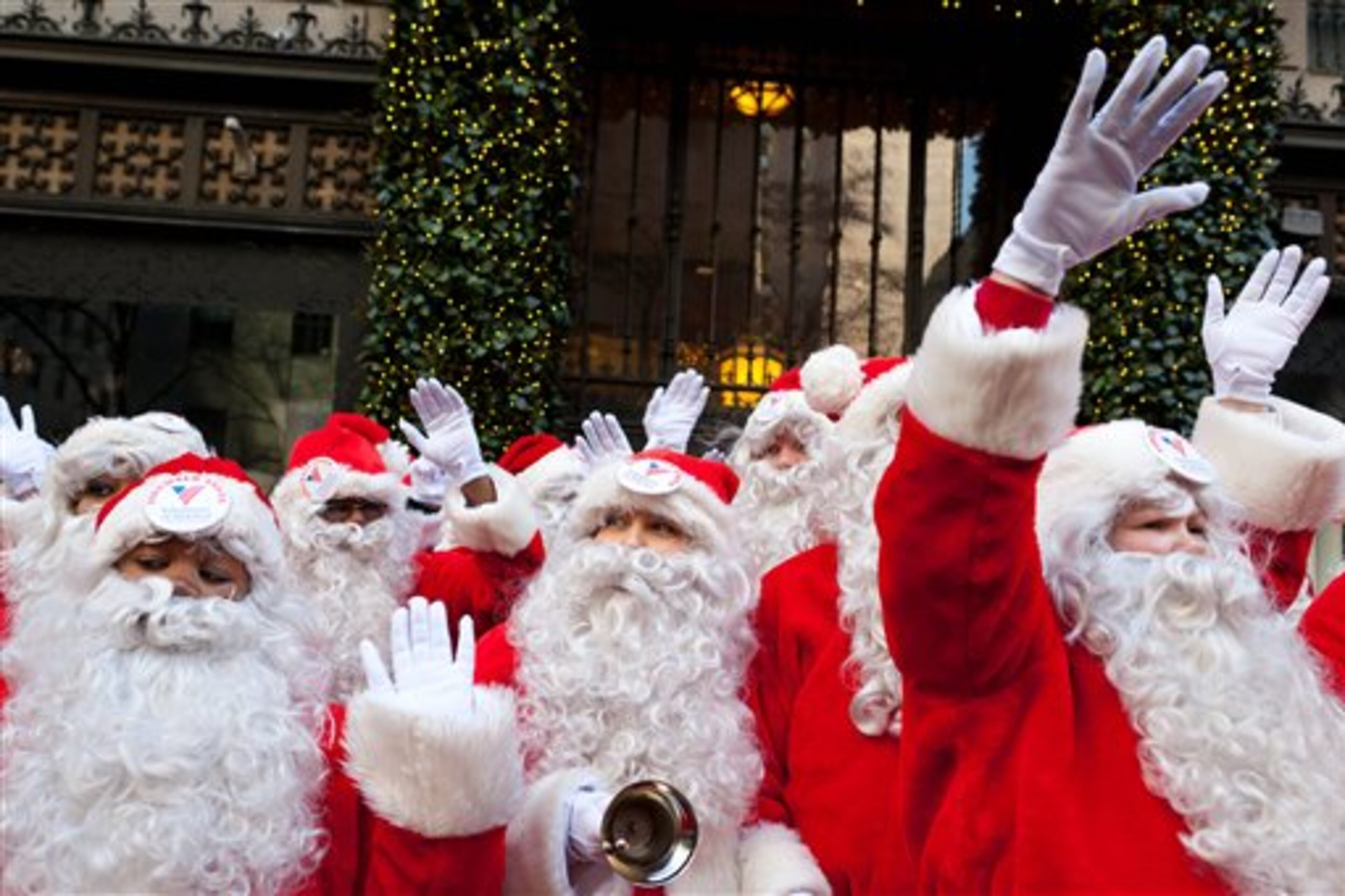 Charity workers dressed as Santa Claus wave to pedestrians on Fifth Avenue during a march of Sidewalk Santas, Friday, Nov. 25, 2011, in New York. Volunteers of America held it's 109th annual Sidewalk Santa Parade on the busiest shopping day of the year to raise money for a holiday food voucher program for needy residents. (AP Photo/John Minchillo)