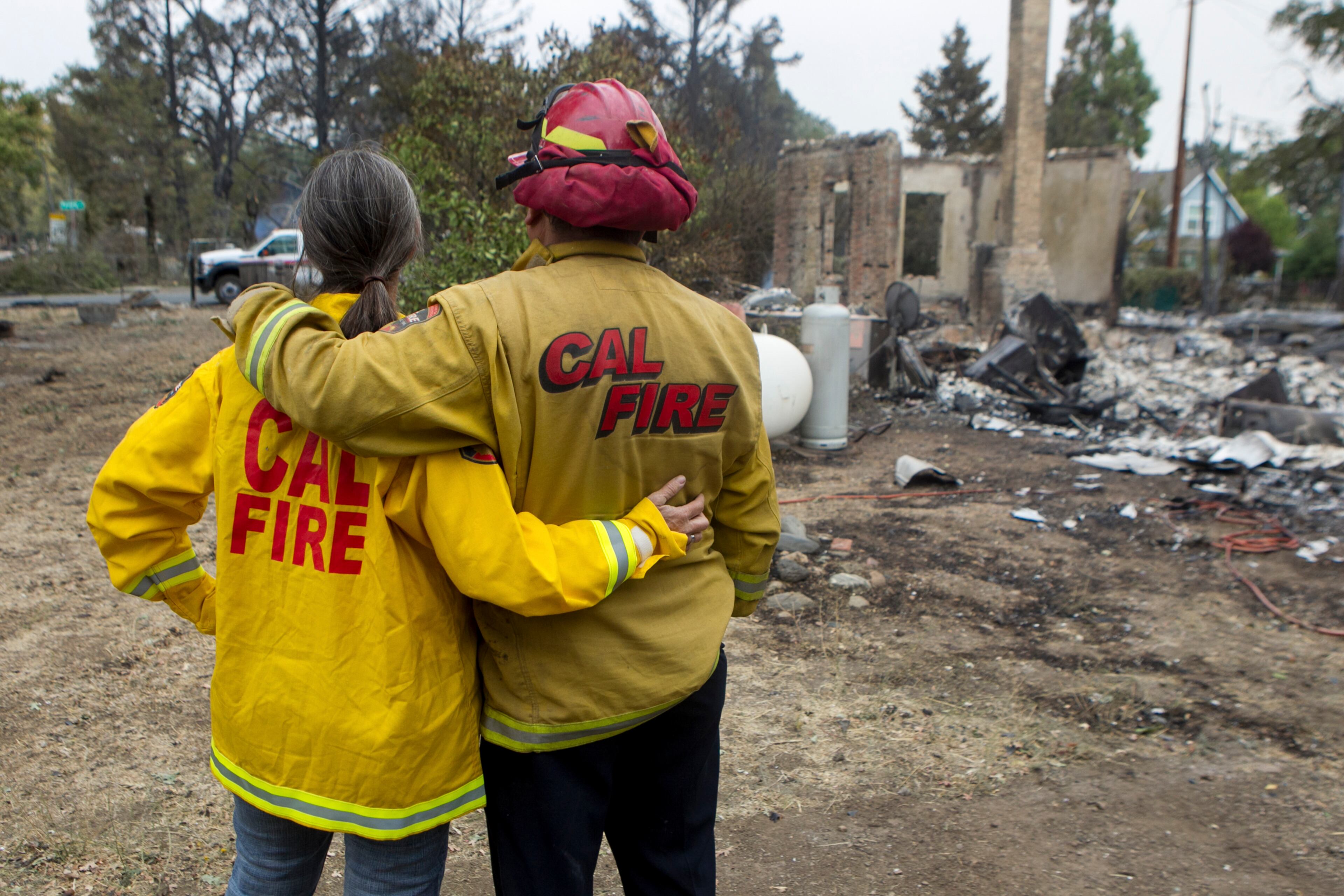 Mike Walton and his wife, Kathy, at the destroyed home of a friend in Middletown, Calif., Sept. 14, 2015. Despite the efforts of thousands of firefighters, three major fires have consumed 270,000 acres, forcing the evacuation of thousands of people, state officials said. (Ilana Panich-Linsman/The New York Times)