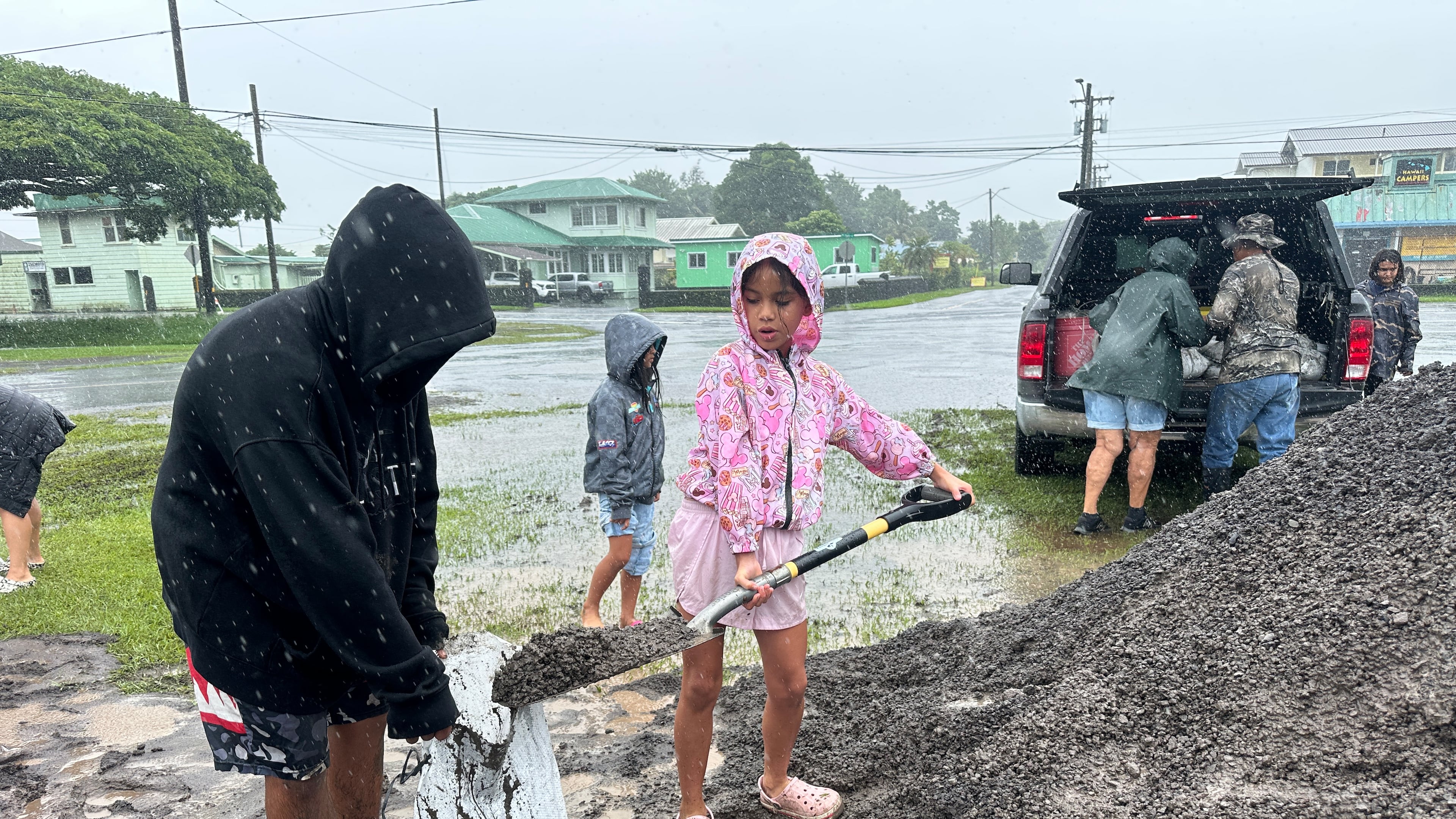 Kenzielynn Kekoa, center, of Hilo, Hawaii, helps her family fill sand bags as Hurricane Nolo approaches in Hilo, Hawaii, Friday, Sept. 25, 2026. (AP Photo/Eugene Garcia)