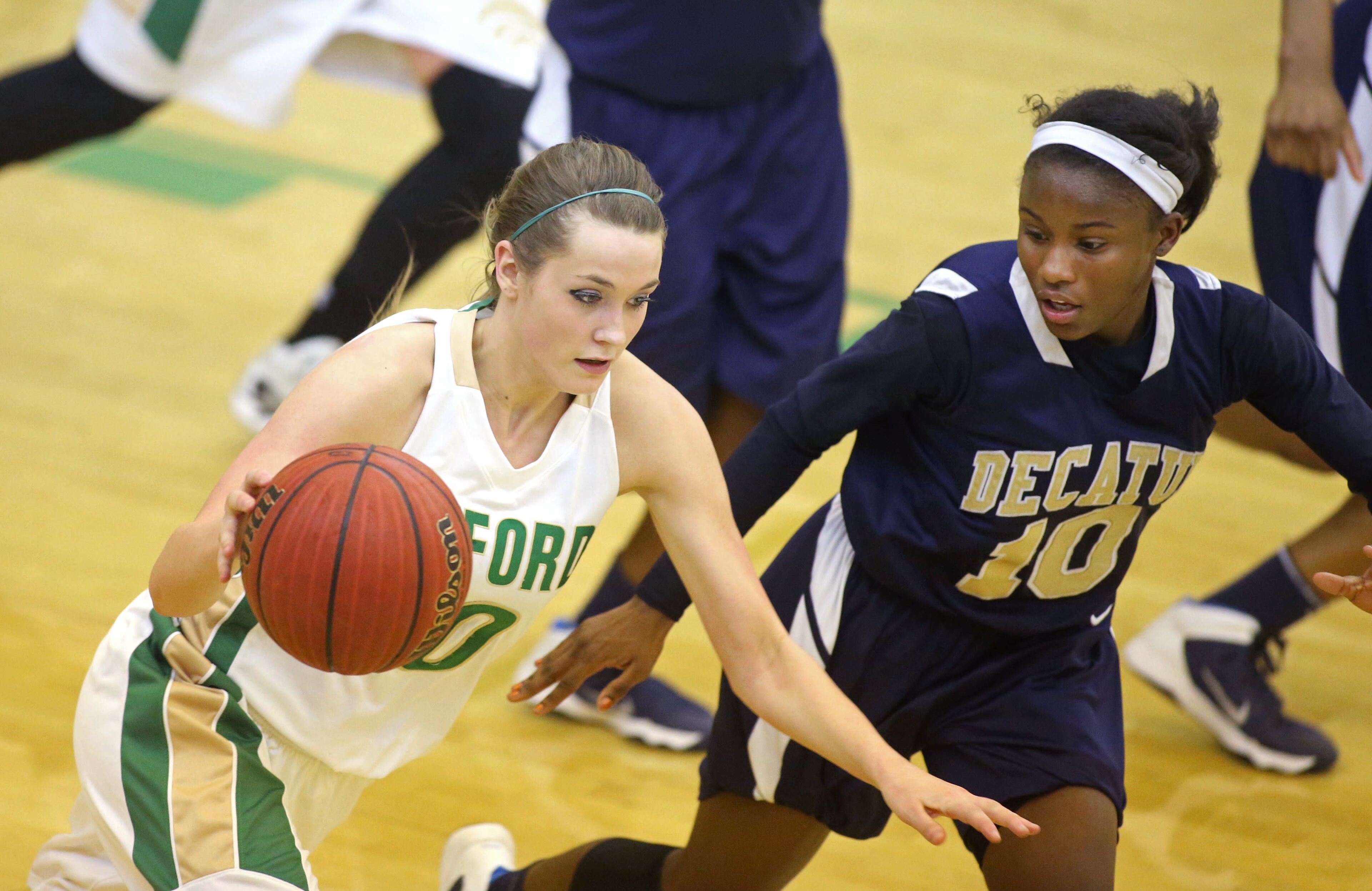 Buford's Taylor Ozment (10) drives against Decatur's Jahmee Reeves, right, in the second round of the Class AAA state basketball tournament on Feb. 24, 2014. Buford defeated Decatur 41-28 . JASON GETZ / SPECIAL