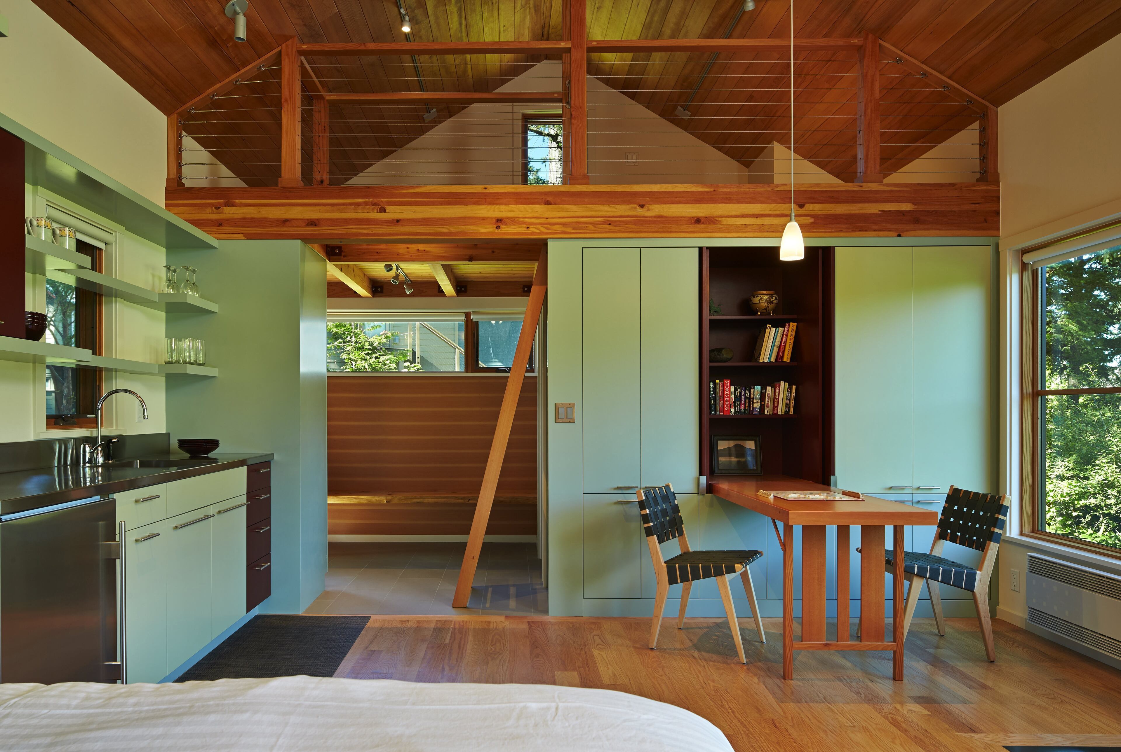 The table and loft stairs in the guest cottage fold out to serve as needed. "The thing about Orcas is, because there's such an influx of guests, you're always trying to design rooms that flex," says architect David Kau. "The joke is that we have nine months of winter and three months of guests." (Benjamin Benschneider/Seattle Times/MCT)