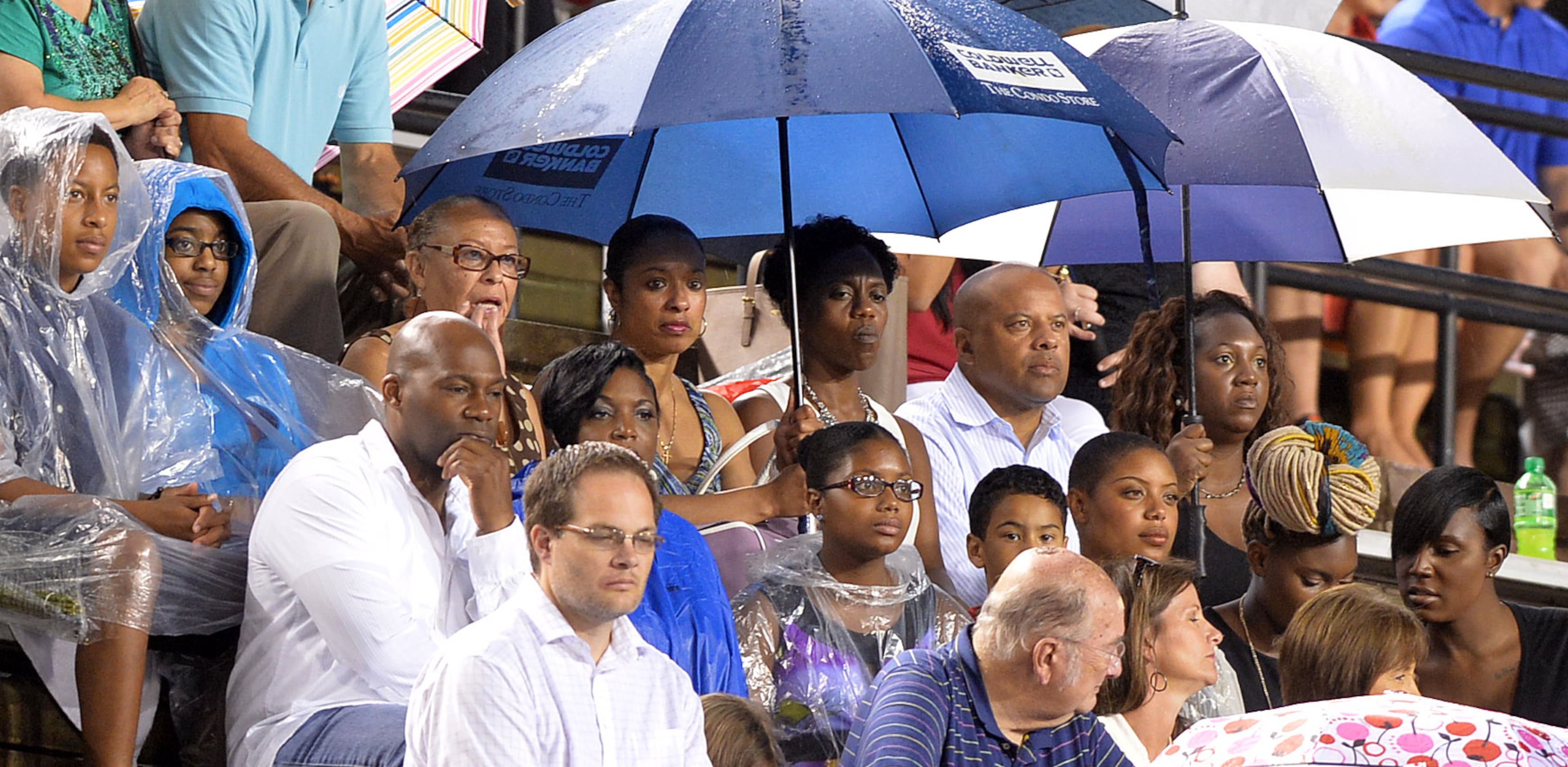 Family members watch the graduates proceed onto the field. Members of the Washington family join together to celebrate the graduation of Tayla Washington, 23, at Jacksonville State University Friday, August 8, 2014. KENT D. JOHNSON / KDJOHNSON@AJC.COM