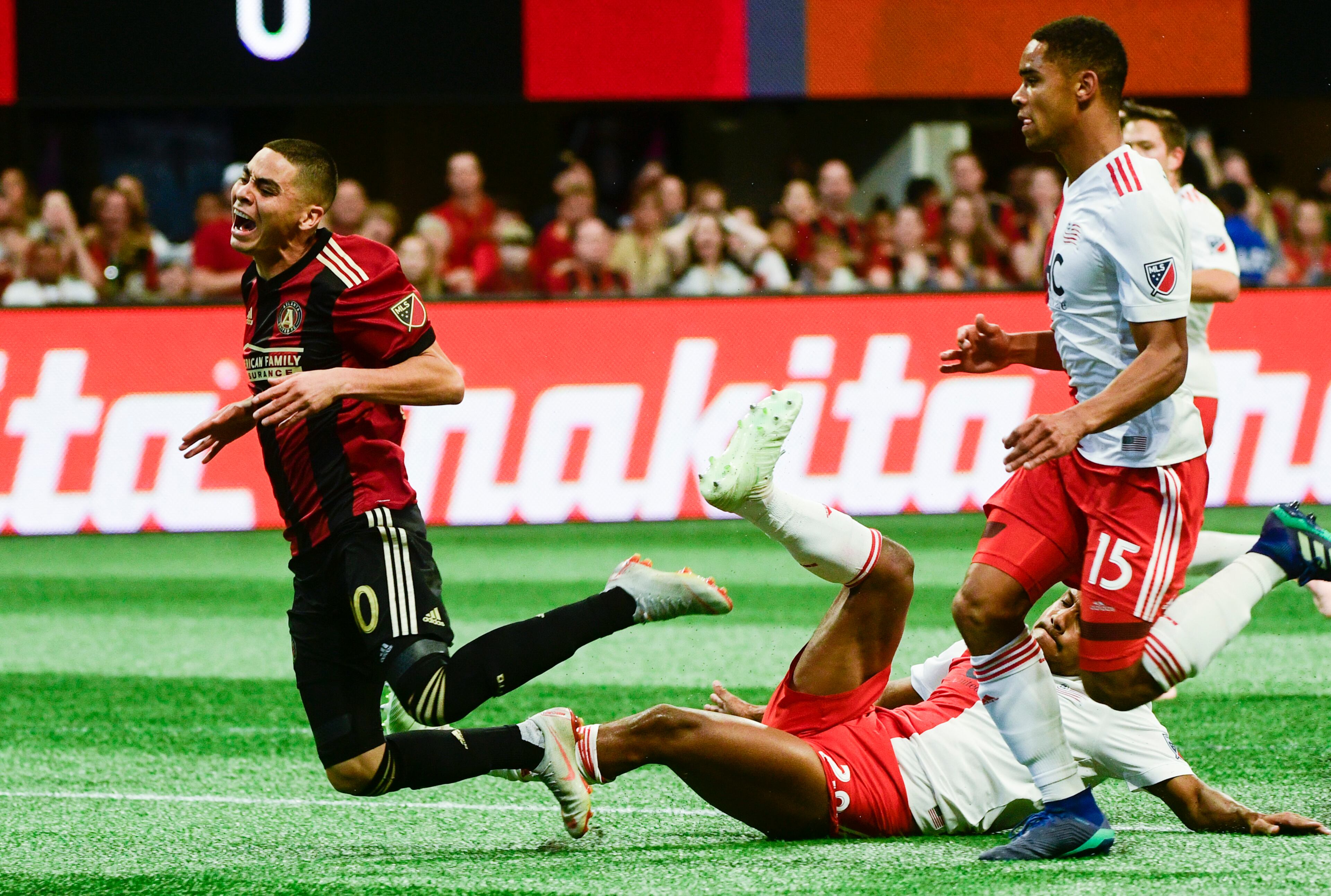 Atlanta United midfielder Miguel Almiron (10) is tripped up by New England Revolution's Michael Mancienne during the first half of an MLS soccer game, Saturday, Oct. 6, 2018. (John Amis)