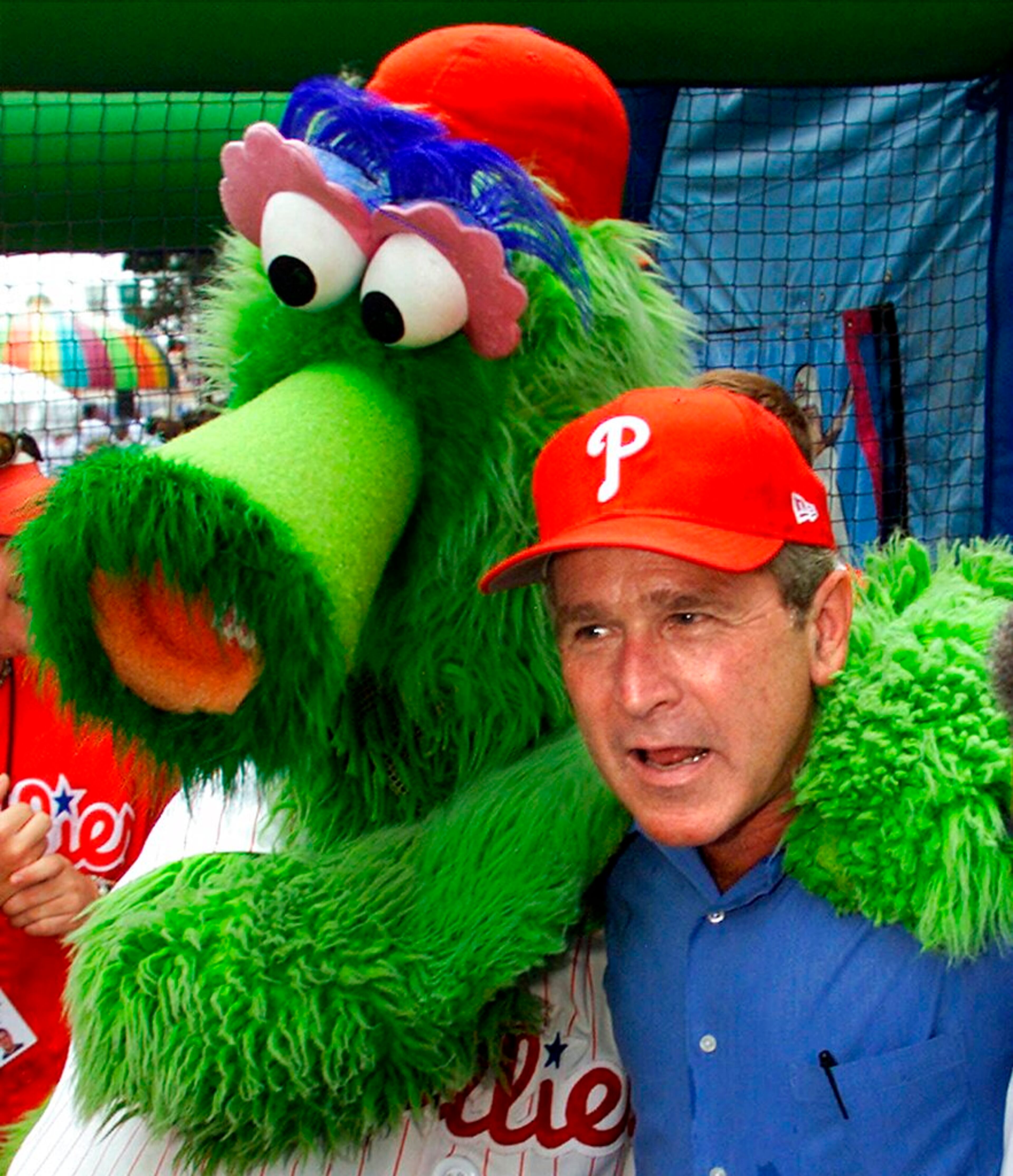 FILE - In this July 4, 2001 file photo, President George W. Bush celebrates the Fourth of July holiday in Philadelphia and poses with that city's baseball mascot, the "Philly Phanatic," at a block party sponsored by the Greater Exodus Baptist Church to promote his faith-based initiative that would enable religious charities to provide government services. (AP Photo/J. Scott Applewhite)