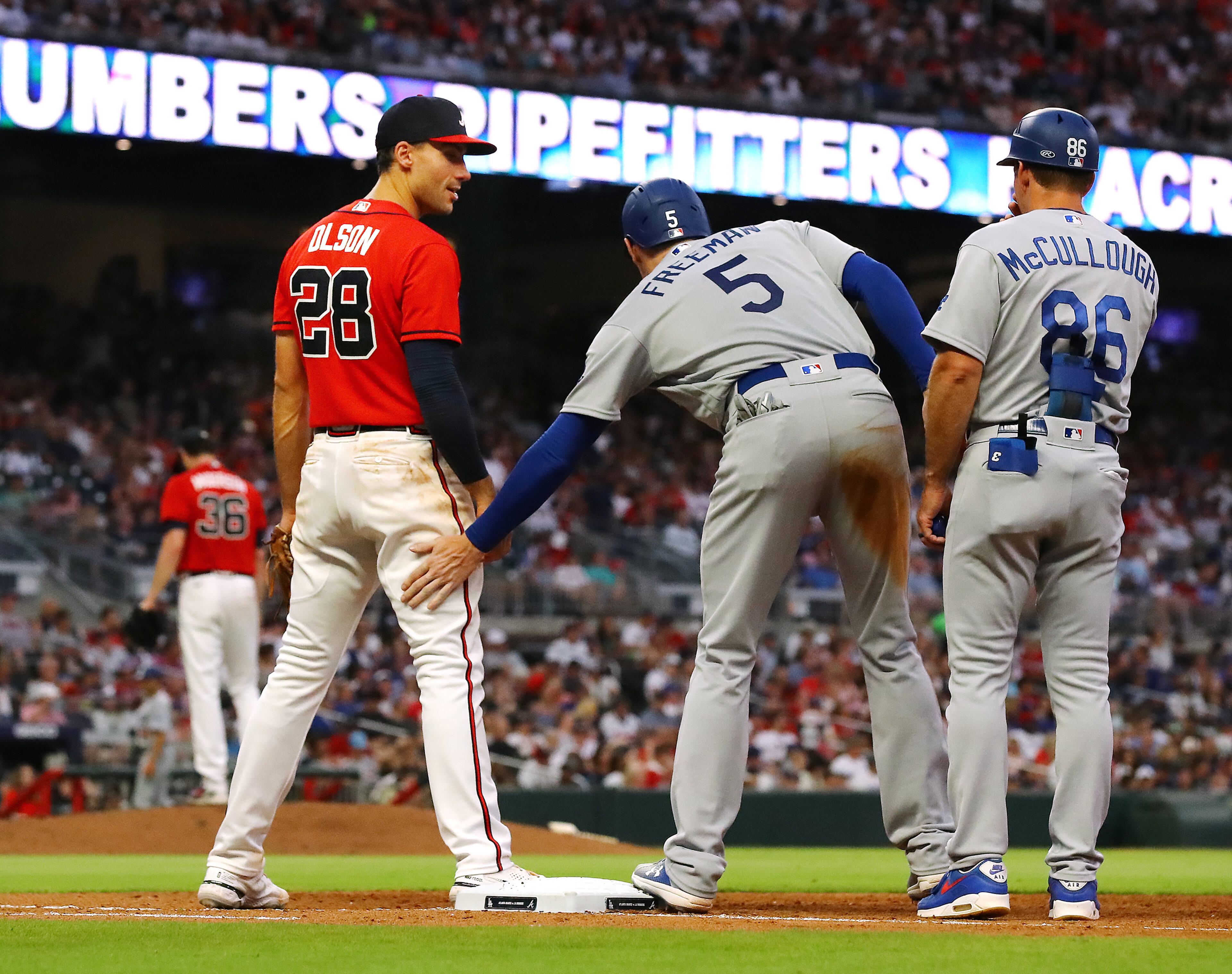 062422 Atlanta: Atlanta Braves first baseman Matt Olson gets a pat on the leg from Los Angles Dodgers first baseman Freddie Freeman after he draws a walk during the fifth inning in a MLB baseball game on Friday, June 24, 2022, in Atlanta. “Curtis Compton / Curtis.Compton@ajc.com”