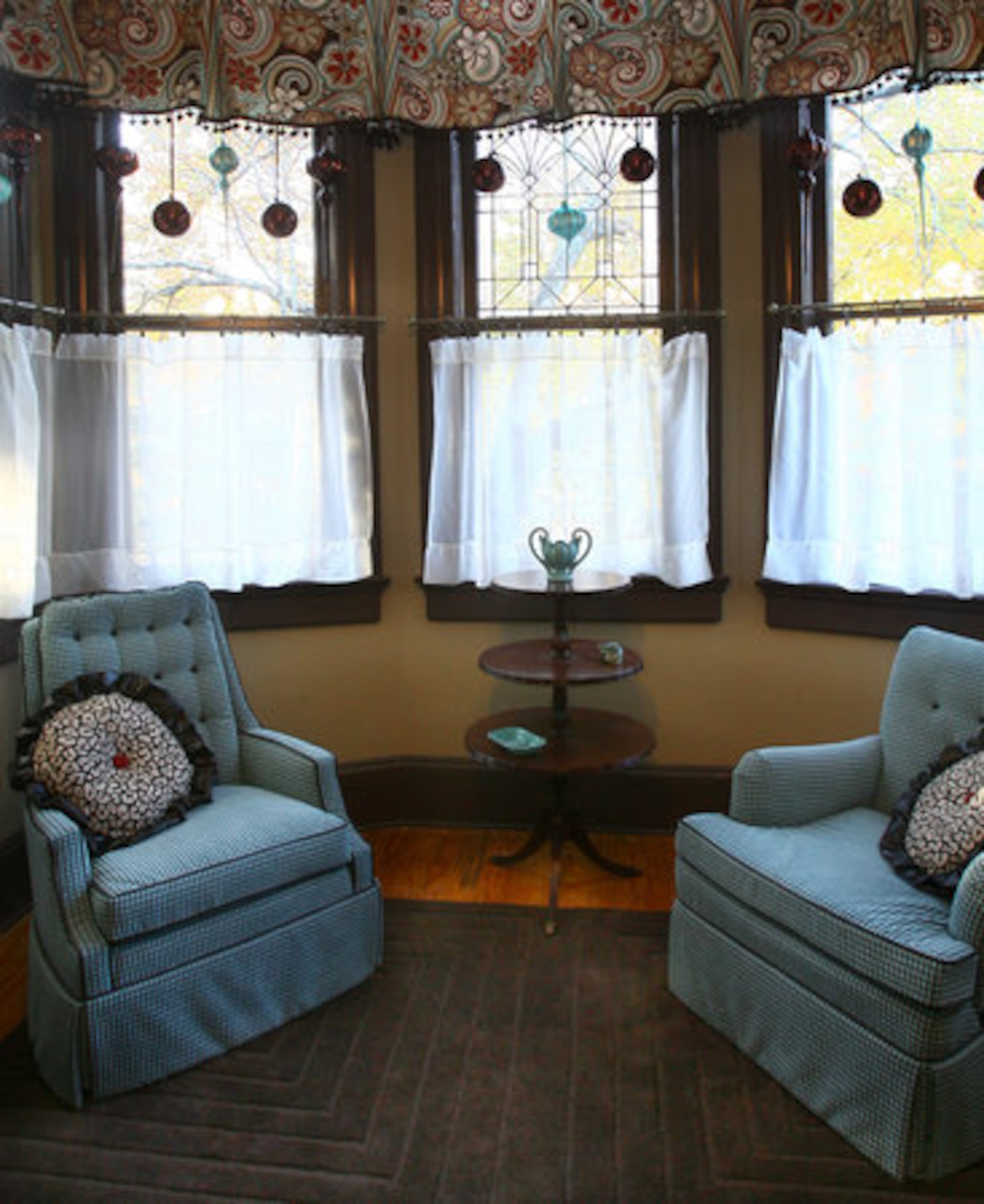 Alert visitors will notice that every inch of the 12-foot ceilings has received its share of attention and special treatment. In one of the bedrooms, that surprise is the ornaments that hang in the windows.