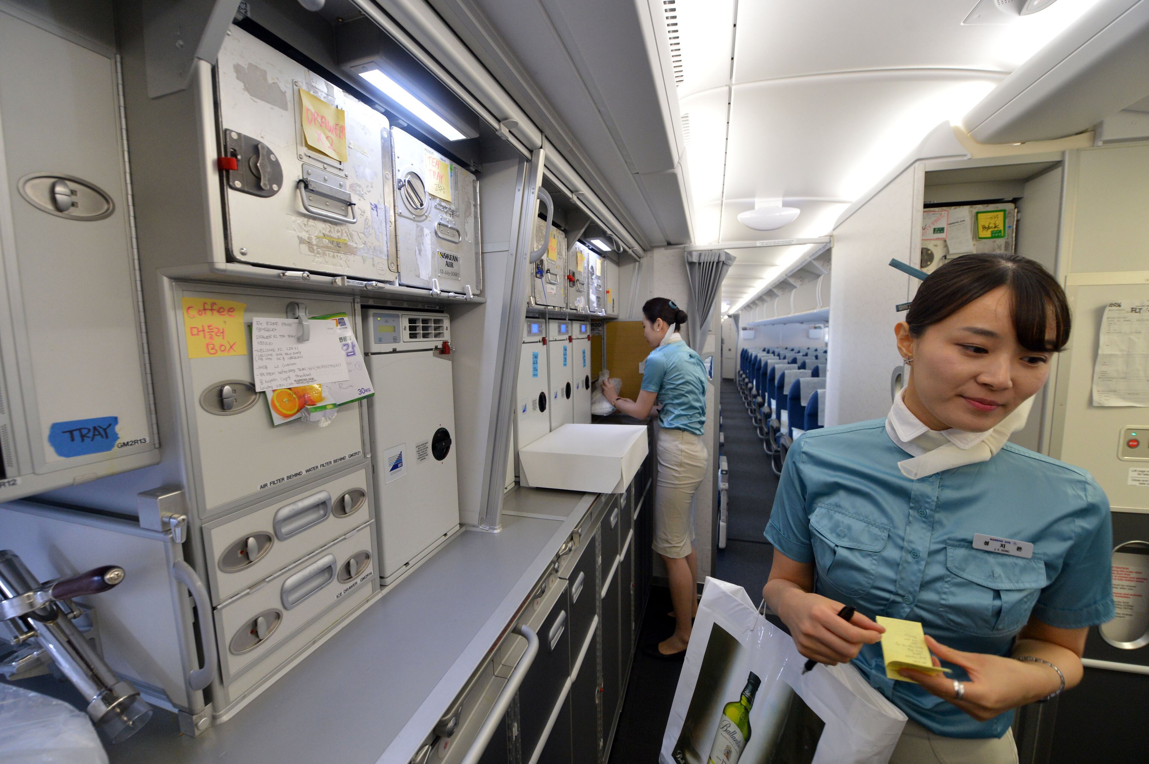 Korean Air flight attendants prepare the plane for the flight to Seoul Friday afternoon. KENT D. JOHNSON / KDJOHNSON@AJC.COM