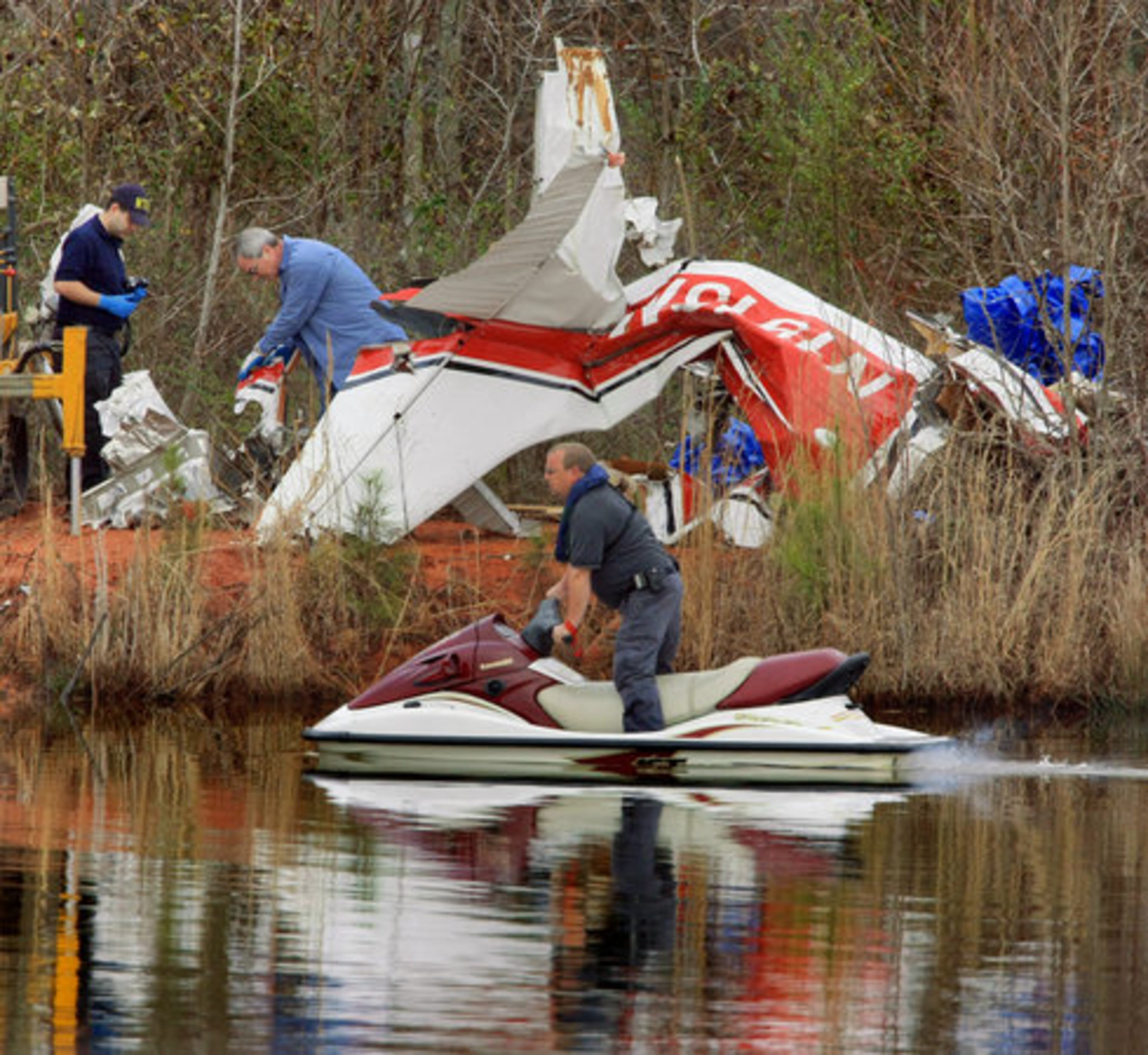 Emergency crews work Monday morning, searching the area at Shadinger Lake near Carrollton where a small plane crashed on Sunday. The Cessna single-engine four-seater was en route to the Kobalt Tools 500 NASCAR race in Henry County.
