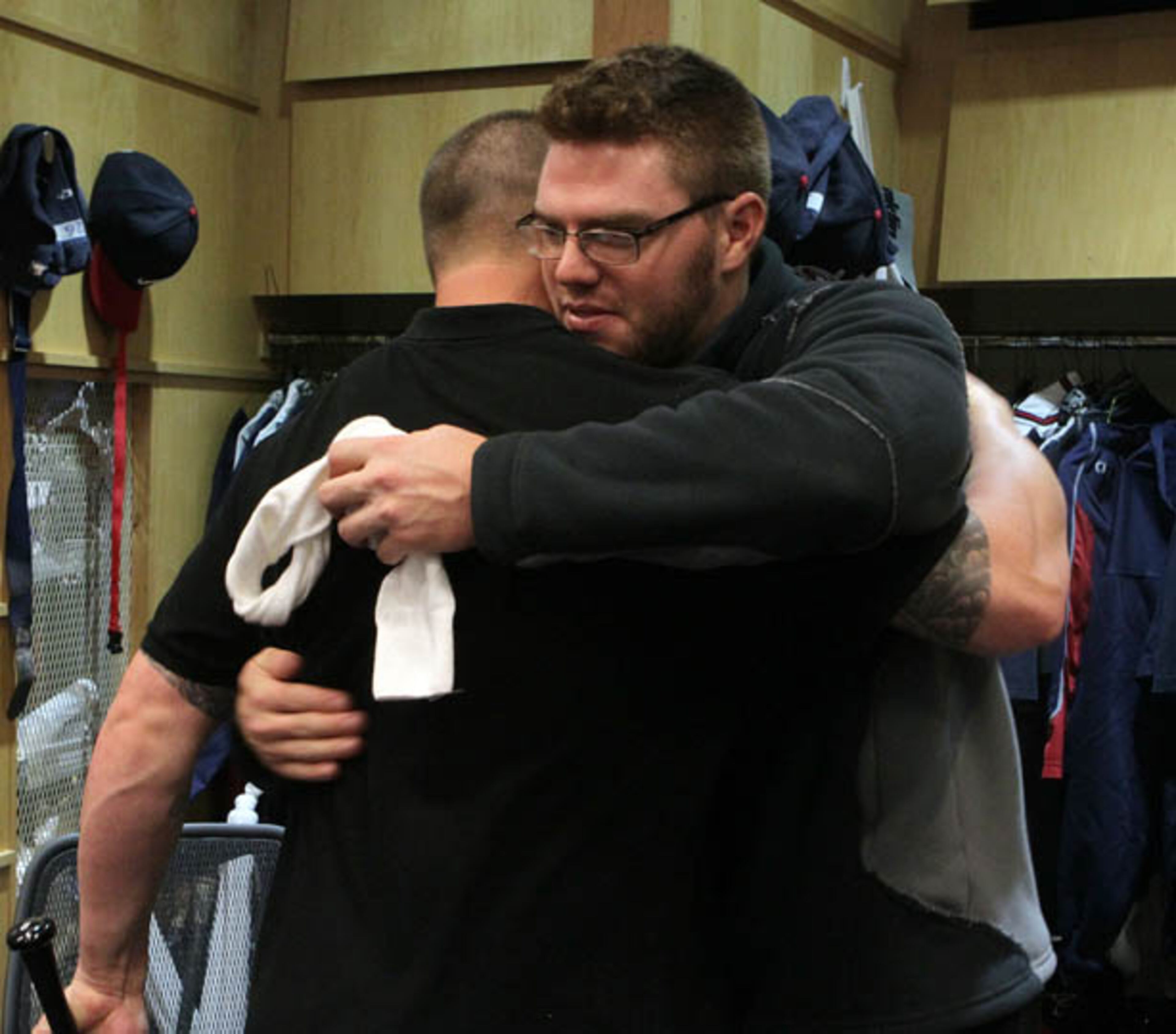 Braves players Eric Hinske (left) and Freddie Freeman say goodbye as they clean out their lockers.