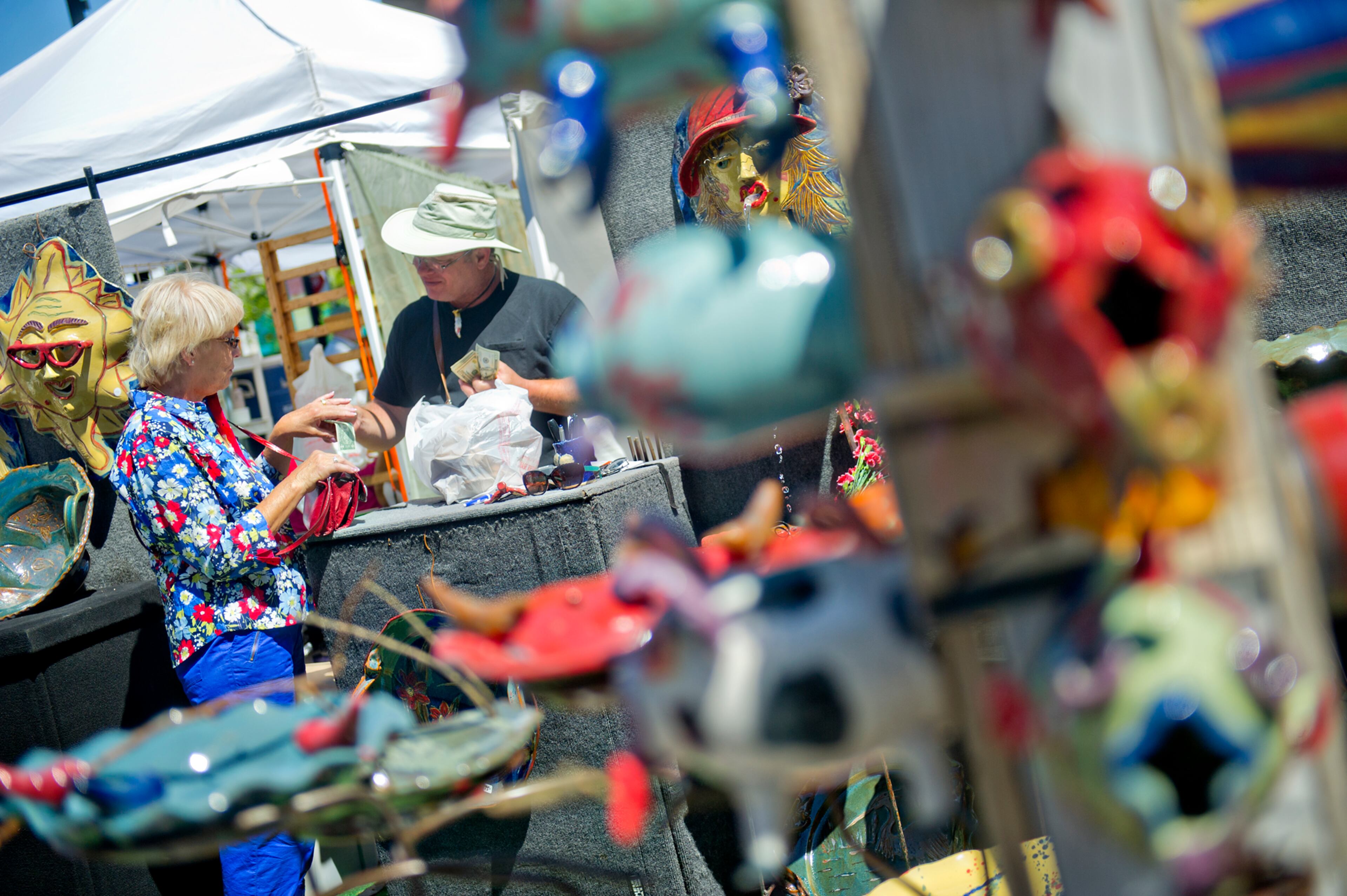 Marilyn Willits (left) buys a piece of pottery from Jerry Mitchell during the May-retta Daze Arts & Craft Festival at Glover Park in Marietta on Sunday, May 4, 2014.