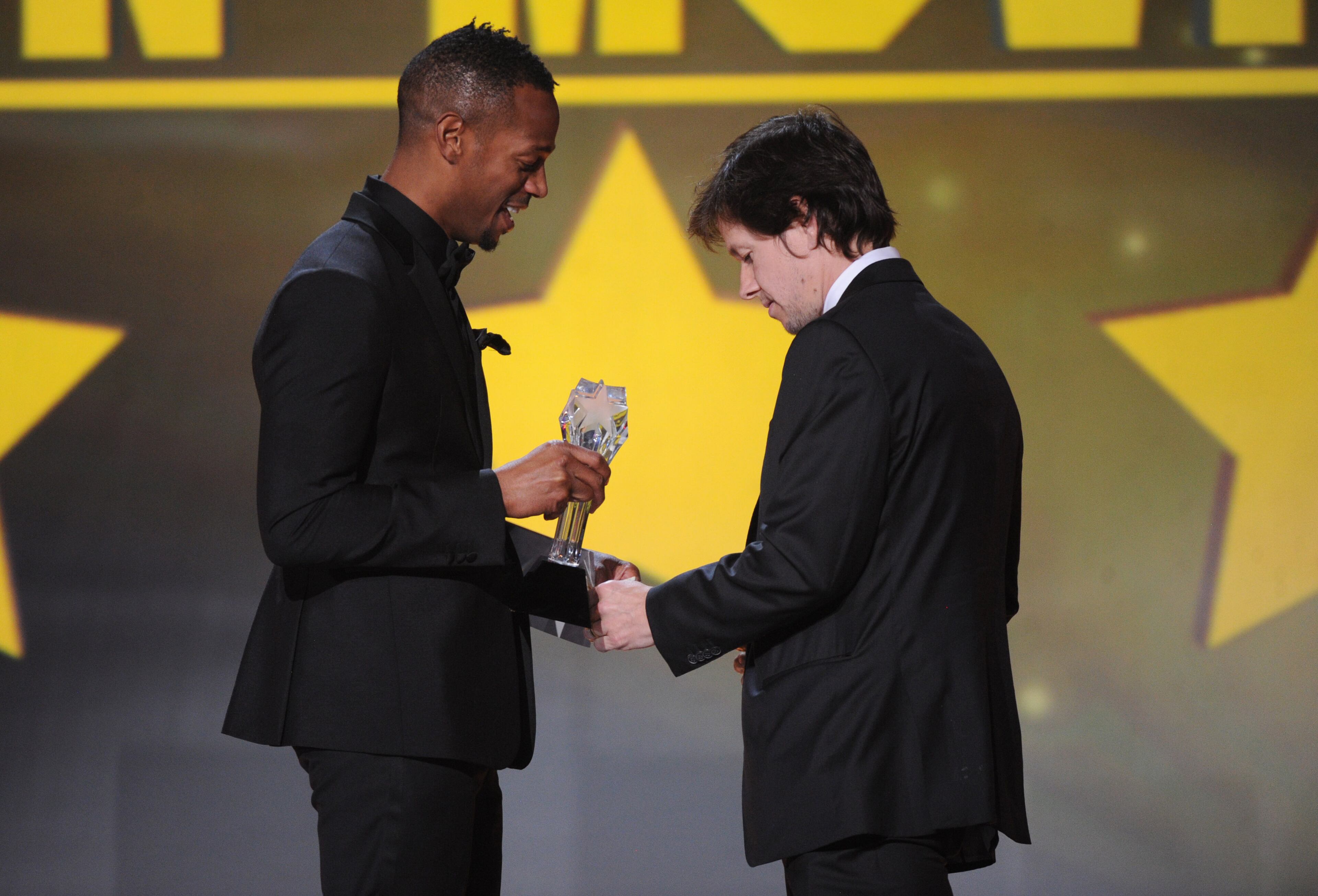 Marlon Wayans, left, presents Mark Wahlberg with the award for best actor in an action movie for "Lone Survivor" at the 19th annual Critics' Choice Movie Awards at the Barker Hangar on Thursday, Jan. 16, 2014, in Santa Monica, Calif. (Photo by Frank Micelotta/Invision/AP)