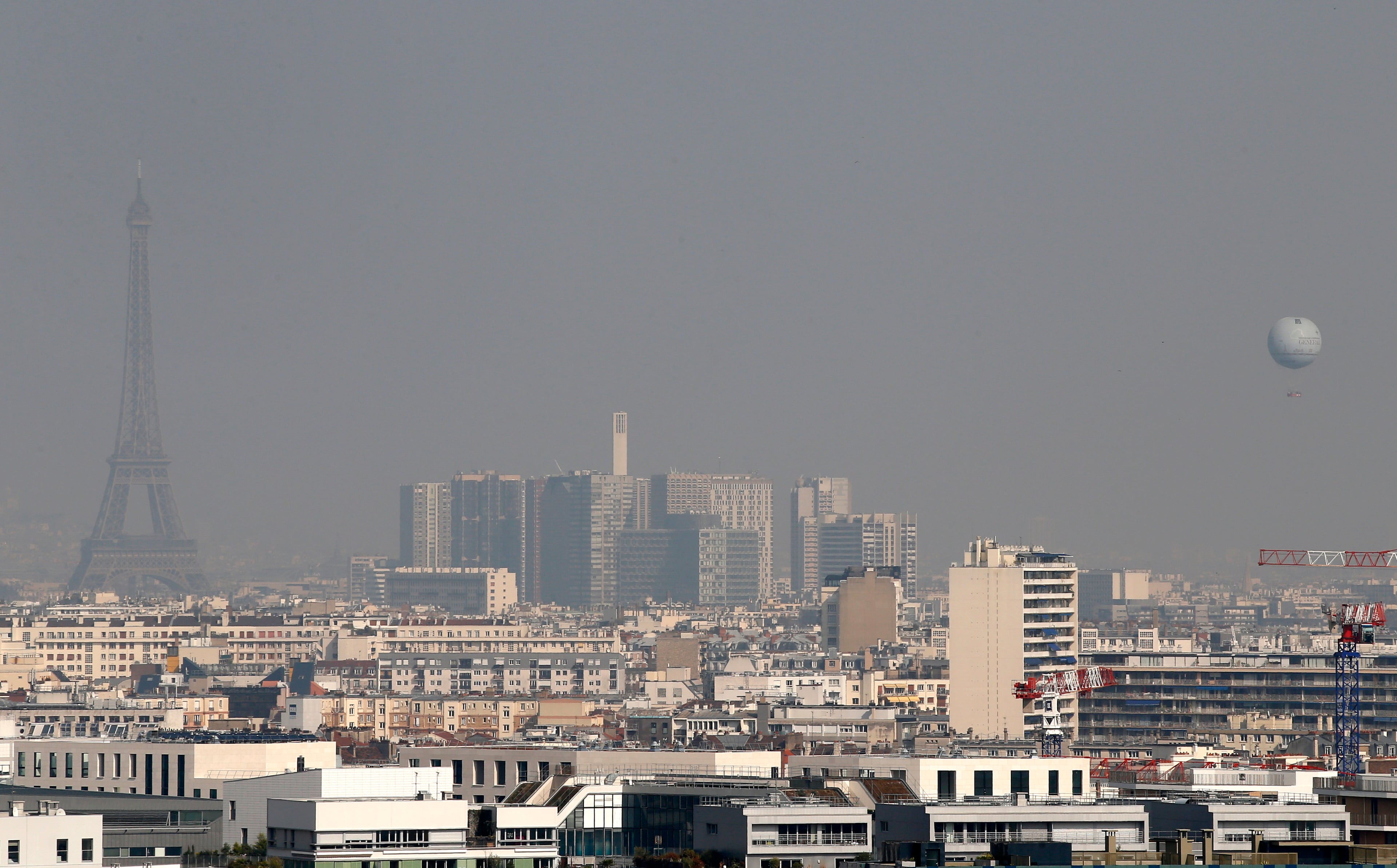 The Eiffel tower and a weather captive balloon are seen through the smog in Paris, Thursday March 13, 2014, as pollution over the French capital is at high levels.