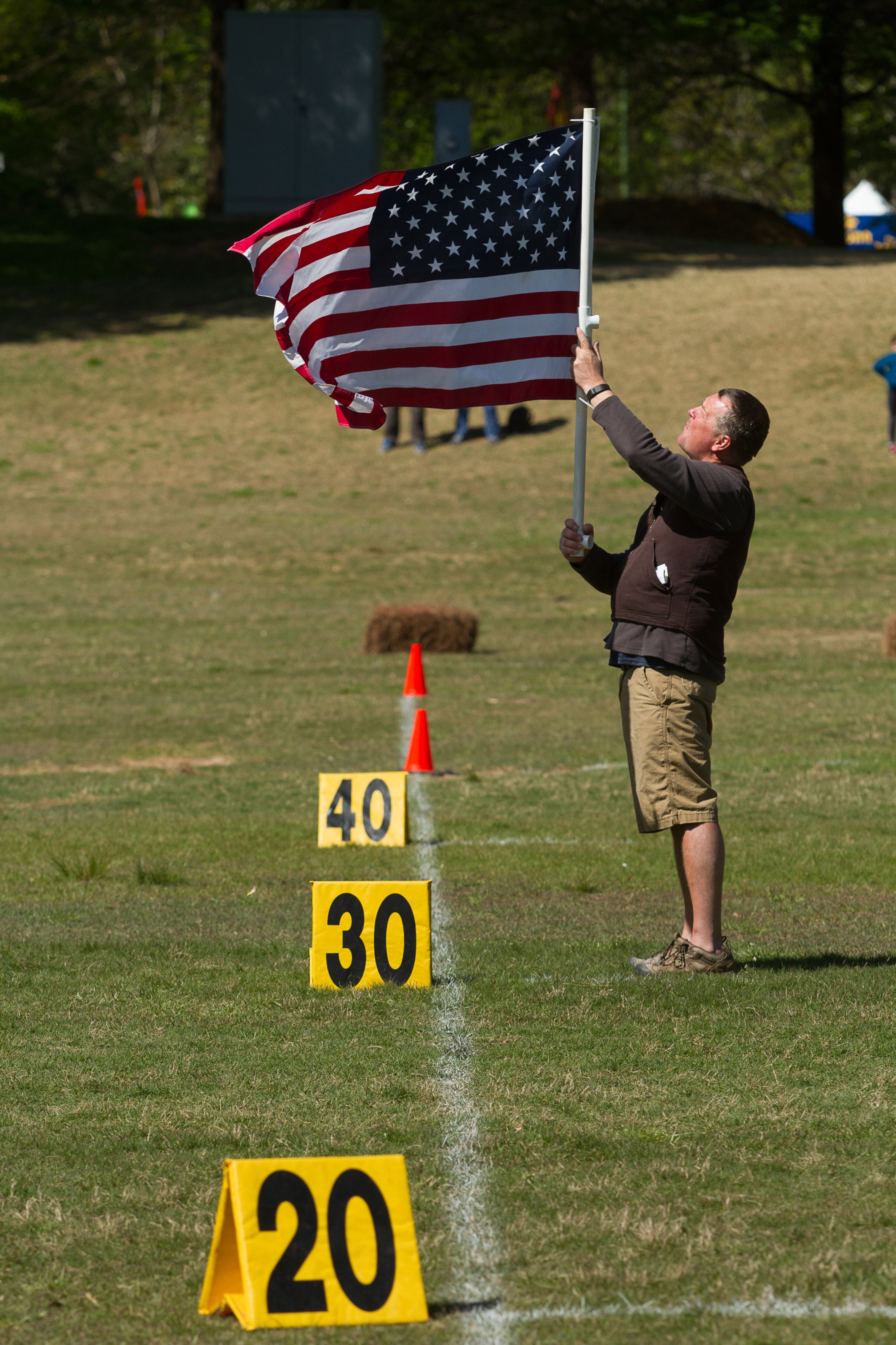 Troy McConaughey holds the American flag during the national anthem at the start of the 2016 Disc Dog Southern Nationals Qualifier tournament at Piedmont Park in Midtown Saturday April 9, 2016. STEVE SCHAEFER / SPECIAL TO THE AJC