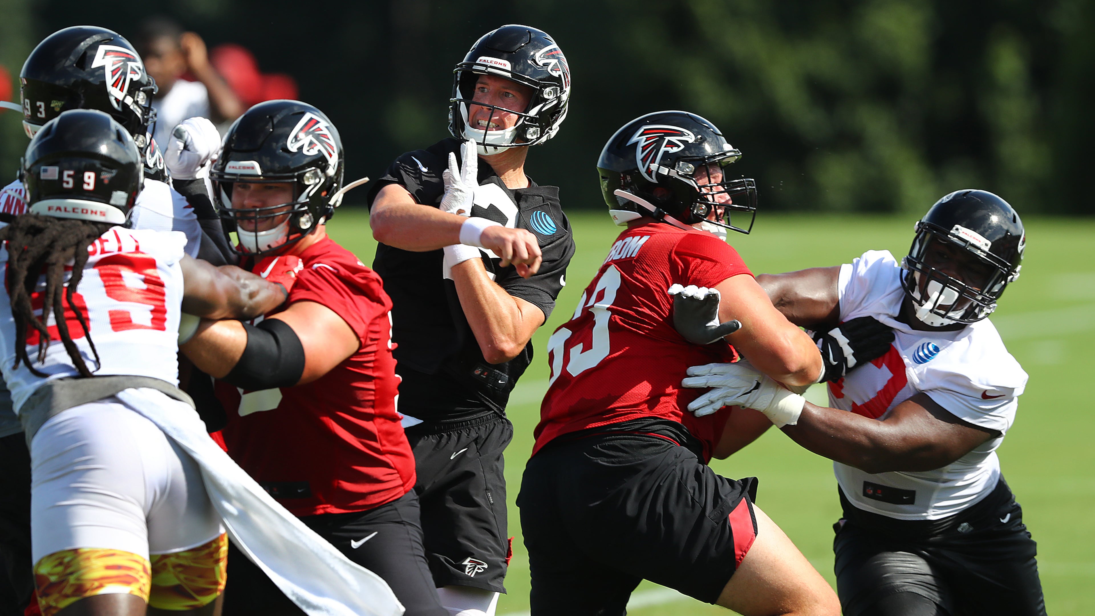 Falcons' first-round draft pick, offensive lineman Chris Lindstrom (right), blocks the rush by defensive tackle Grady Jarrett as Matt Ryan gets off a pass during the first practice of training camp Monday, July 22, 2019, in Flowery Branch.