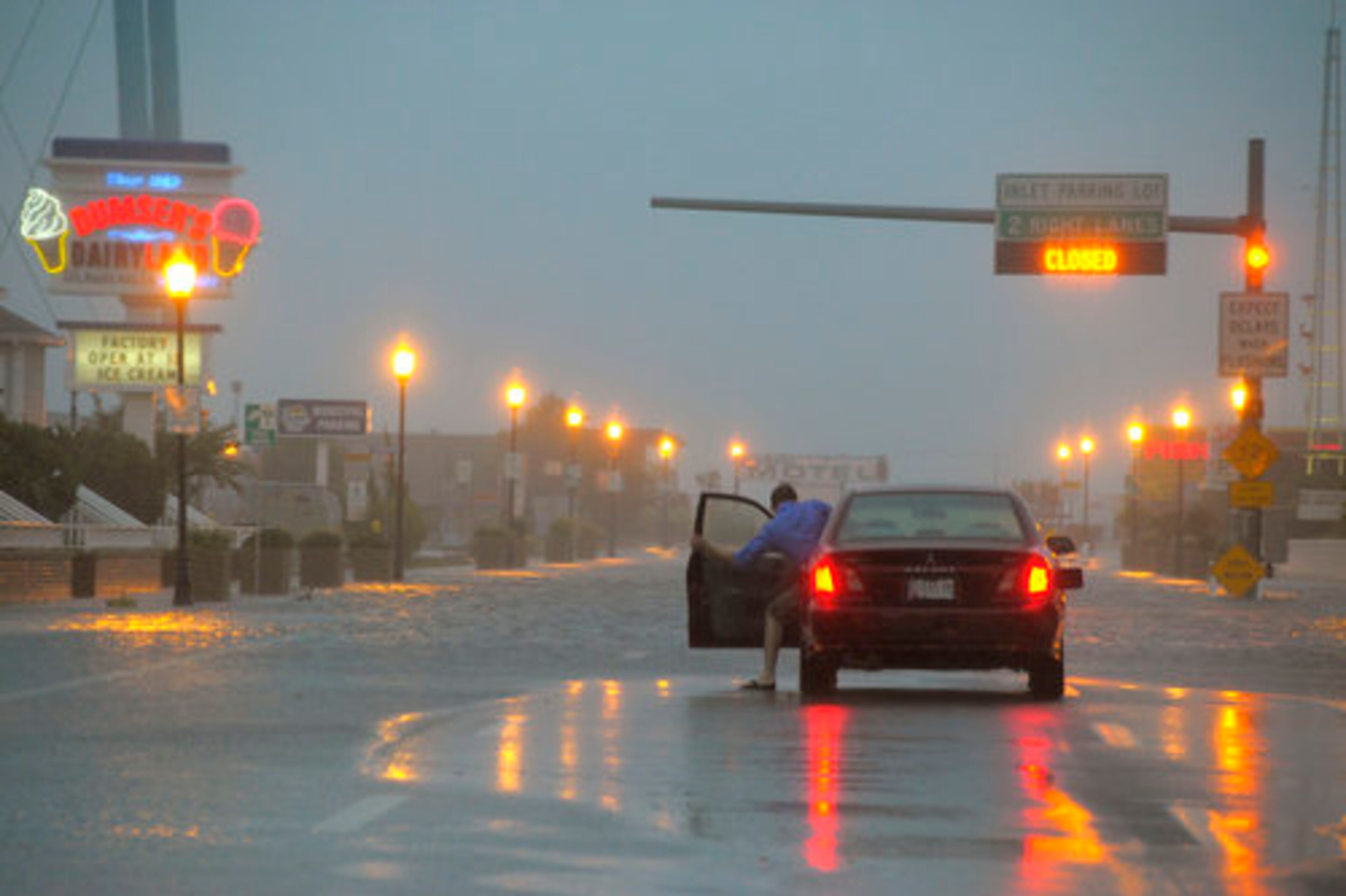 A motorist retreats to his vehicle after realizing that the flood water is too deep for his car to attempt on S. Philadelphia Ave. in Ocean City, Maryland, as rain and winds preceding the full impact of Hurricane Irene reach the area, Saturday, August 27, 2011.