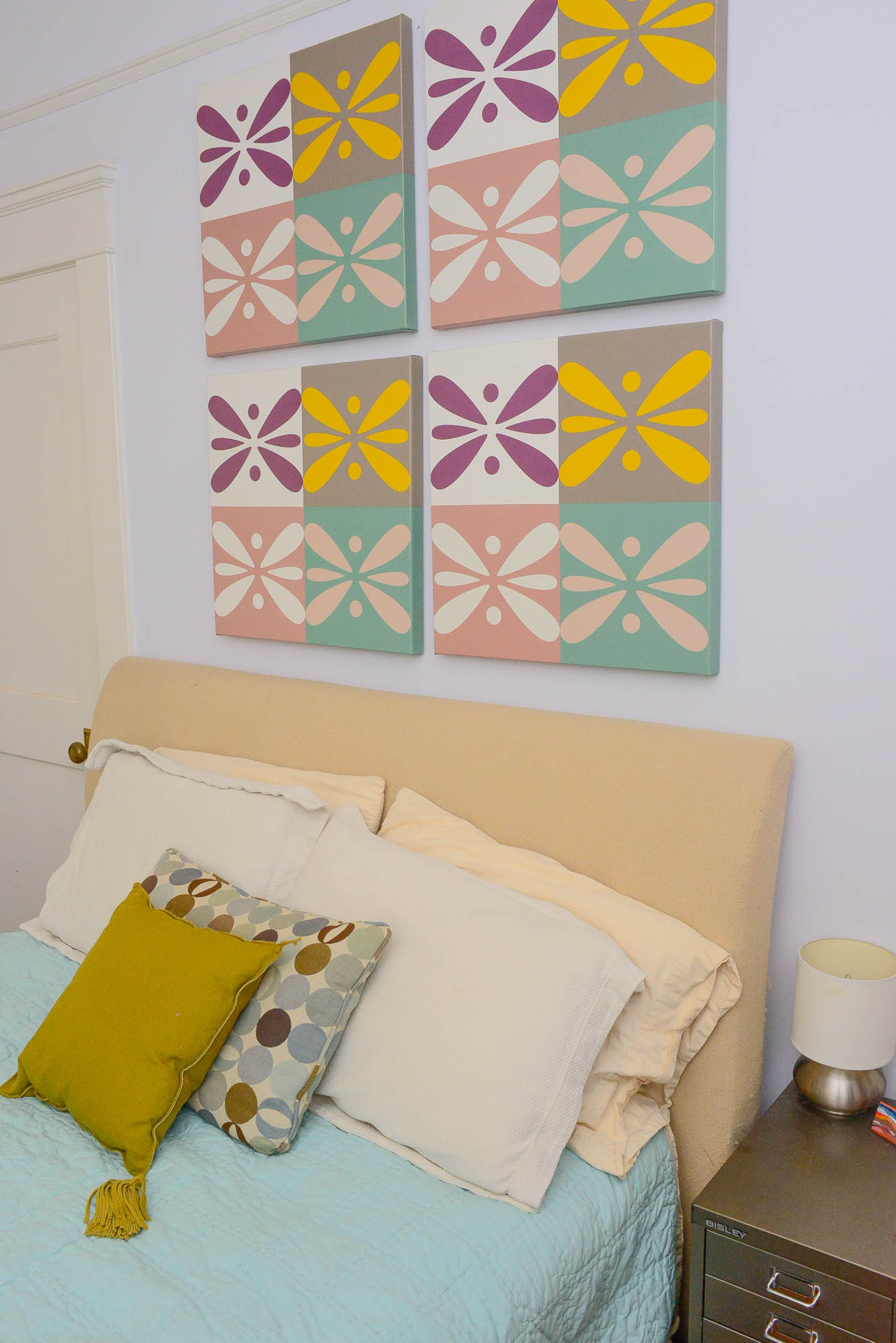 An upholstered bed, bedding and colorful, whimsical art from West Elm set the stage for an inviting guest room.