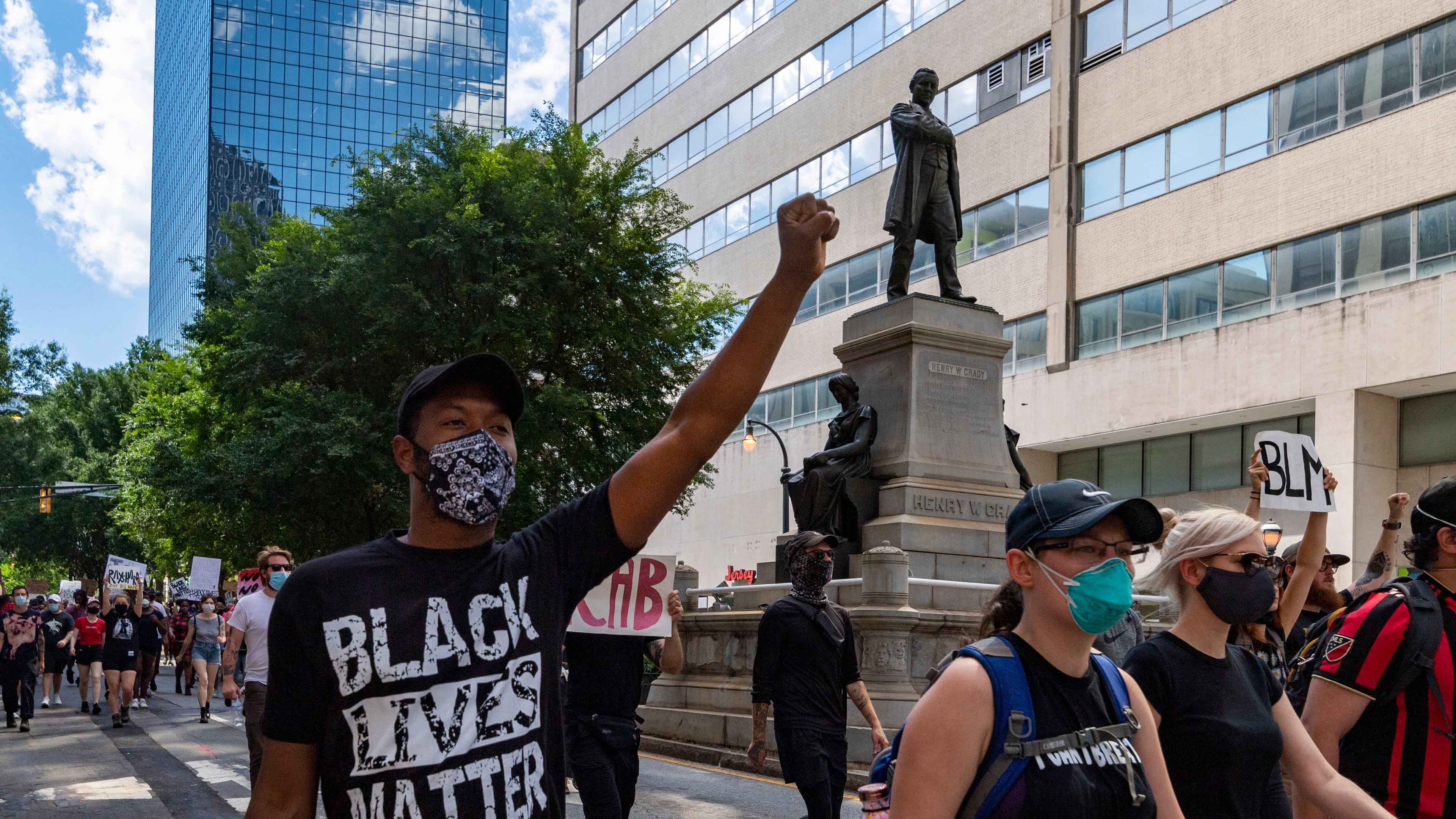 Protesters walk down Marietta Street on June 13, 2020, past a statue of orator and journalist Henry Grady, during a rally over police shootings. There are increasing calls to erase Grady's name from buildings, including Grady High School. JOHN AMIS FOR THE ATLANTA JOURNAL-CONSTITUTION.