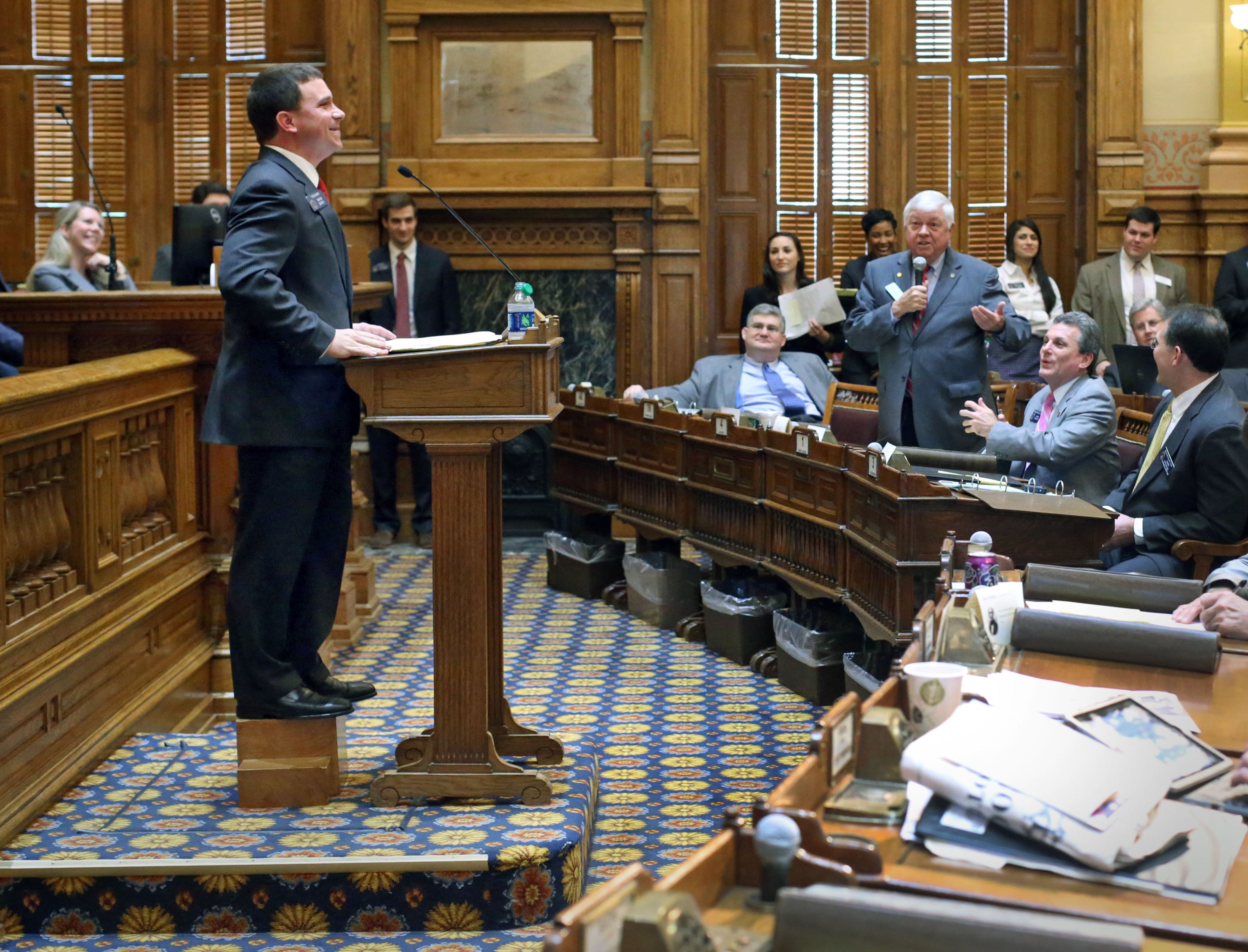 Freshman Sen. Tyler Harper, R-Ocilla, stands on a stool at the podium as he gets "hazed" by Sen. Jack Hill, R-Reidsville, right, as Sen. Harper introduces his first bill, Senate Bill 91, in the Senate chambers Wednesday, Feb. 13. Every time a freshman senator sponsors his or her first bill, fellow senators "haze" them in the Senate chambers as a sort of rite of passage. Because of his height, Lt. Gov. Casey Cagle made Sen. Harper stand on a stool as Cagle said, "So we can see you."