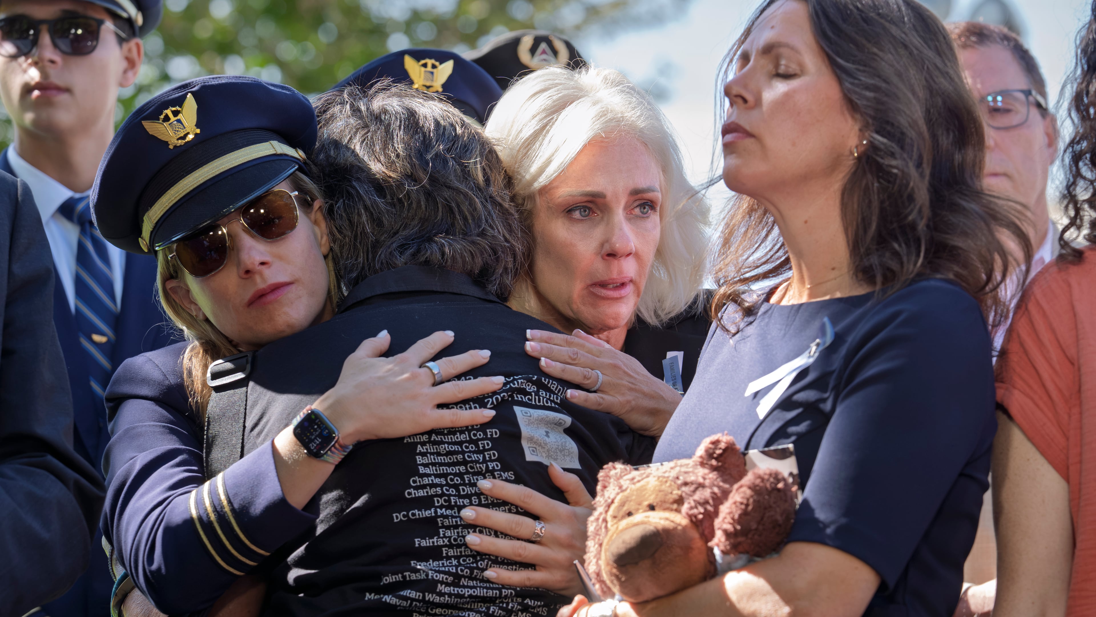 National Transportation Safety Board Chair Jennifer Homendy, center, helps to comfort Christina Stovall, center with back to camera, and Laura Augendre, right, family members of victims of flight 5342, the deadly Jan. 2025 midair collision between an American Airlines plane and a Black Hawk helicopter over the Potomac River, during a news conference on air safety reforms, at the Capitol in Washington, Tuesday, Sept. 15, 2026. (AP Photo/J. Scott Applewhite)
