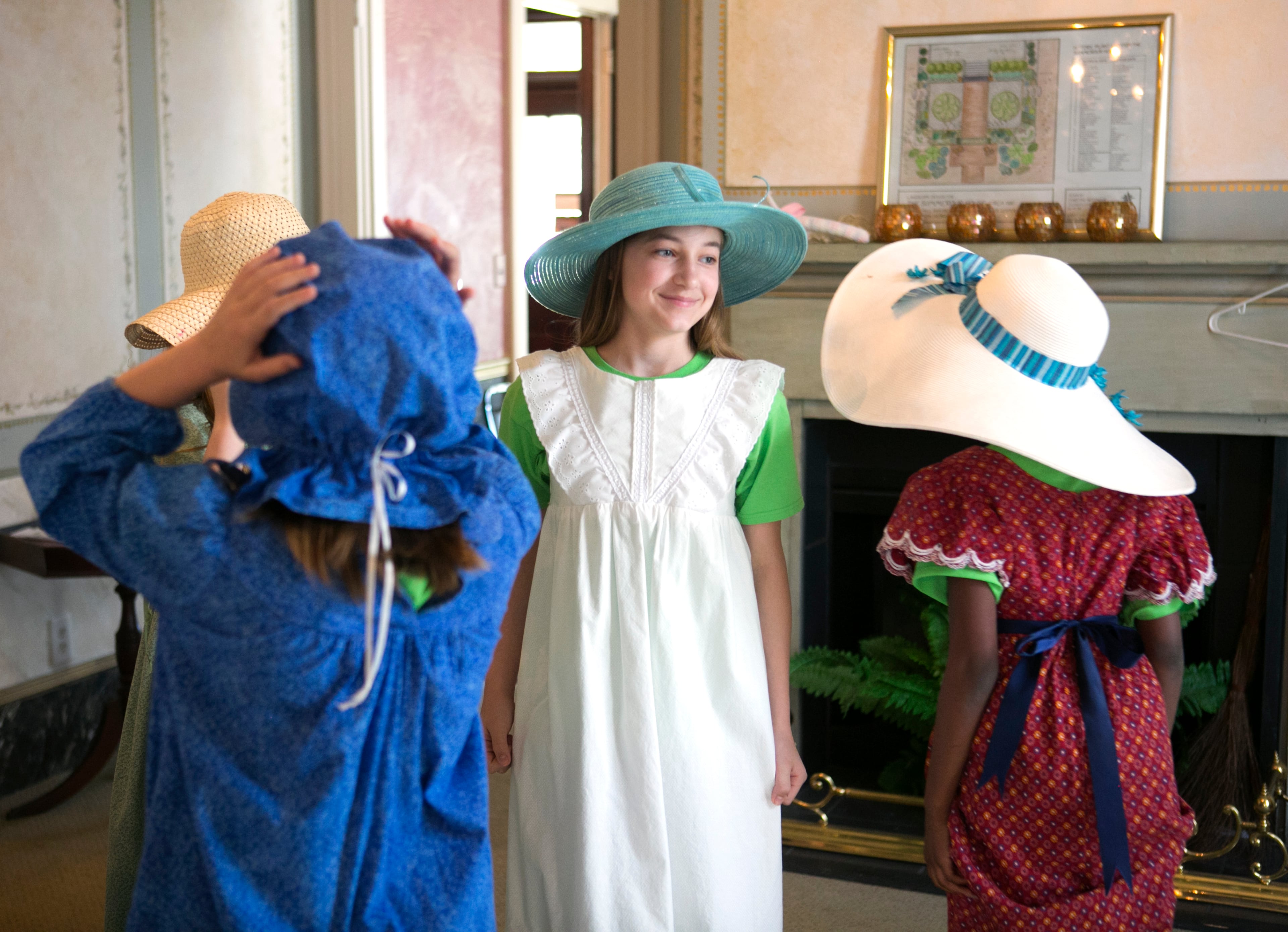 April 2, 2016 - Johns Creek, Ga: Amanda Robinson, 11, center, and other members of the junior girl scout Troop 4564, of Grayson, wear period reproductions of clothing in the Summerour Farmhouse at the Autrey Mill Nature Preserve & Heritage Center Saturday, April 2, 2016, in Johns Creek, Ga. The group of five 5th grade girls were working on their "playing the past" badges. The Summerour House is a Victorian farmhouse built in the 1880's. This is for the insider's guide feature about the Newtown neighborhood. PHOTO / JASON GETZ