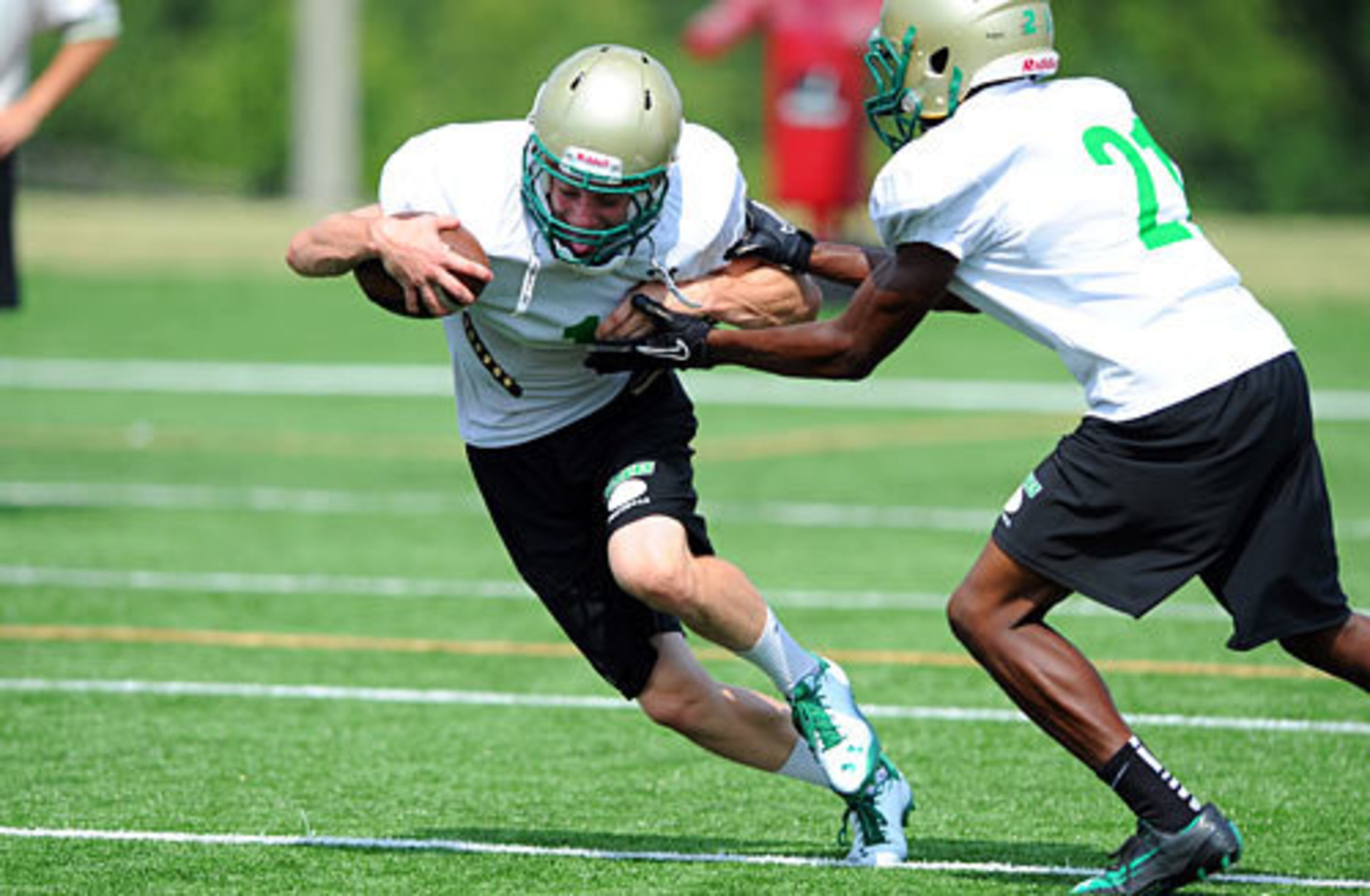 Buford's Michael Lane (1) tries to break a tackle by Thomas Wilson (21).