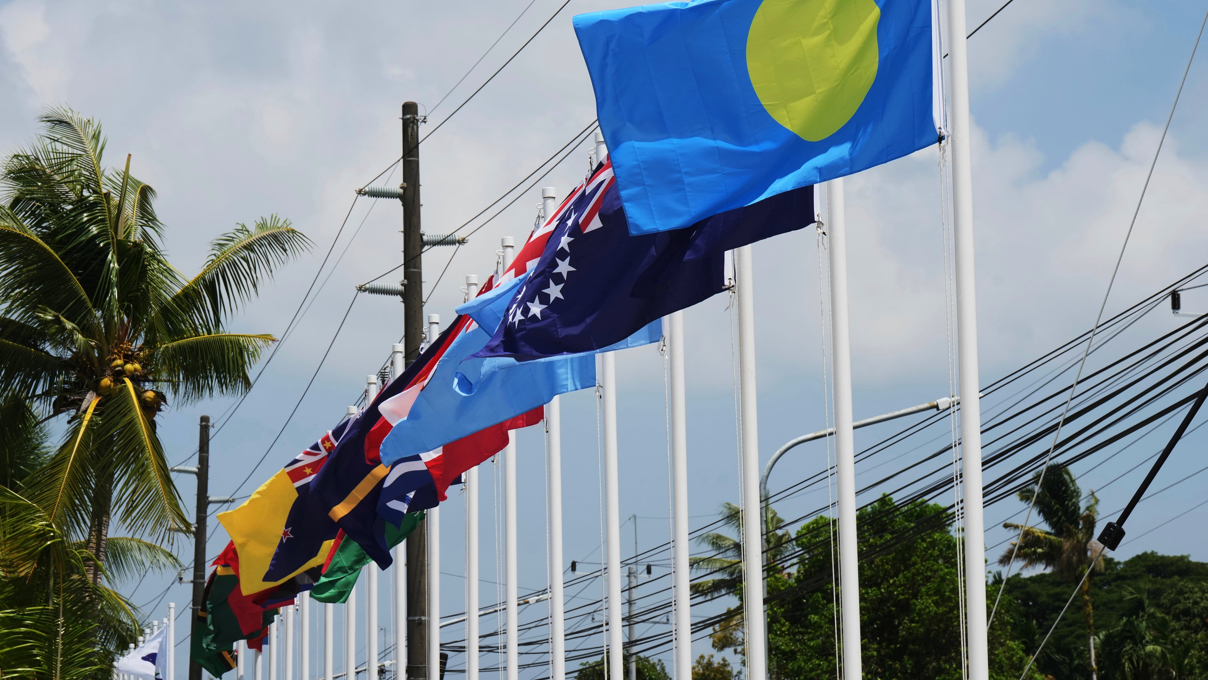 Flags of member states fly outside the summit venue for the Pacific Islands Forum Leaders Meeting in Koror, Palau, Sunday, Aug. 30, 2026. (AP Photo/Charlotte Graham-McLay)