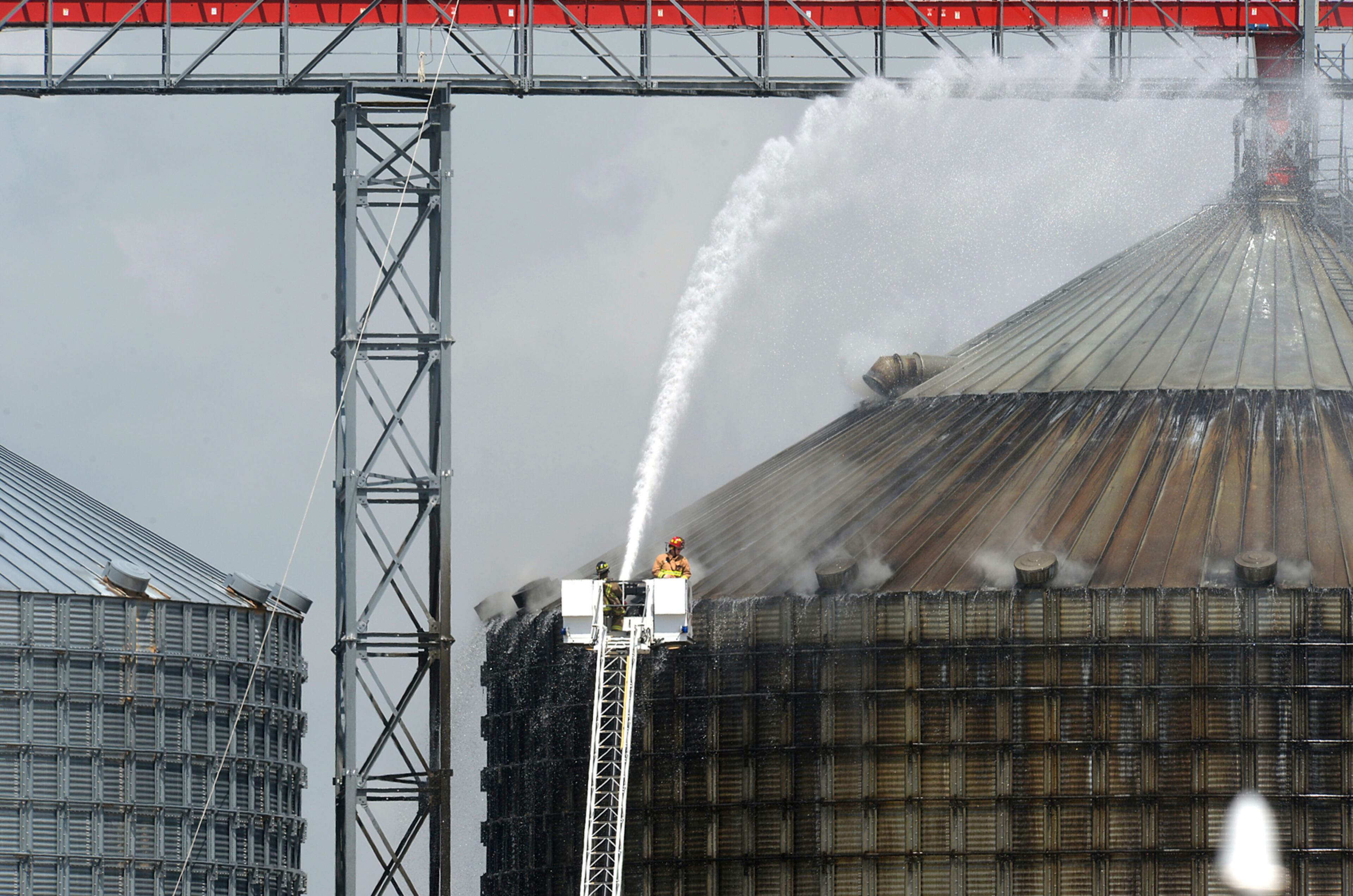 Firefighters spray water on a silo to cool 10,000 tons of smoldering wood pellets at the Port of Port Arthur, Texas, Monday, April 17, 2017. According to city spokeswoman Risa Carpenter, hot spots located by officials Saturday evening ignited early Sunday due to a temperature spike. City firefighters extinguished the flames and began cooling the structure. Port of Port Arthur Director Floyd Gaspard said the fire was started by "internal combustion." (Guiseppe Barranco/The Beaumont Enterprise via AP)